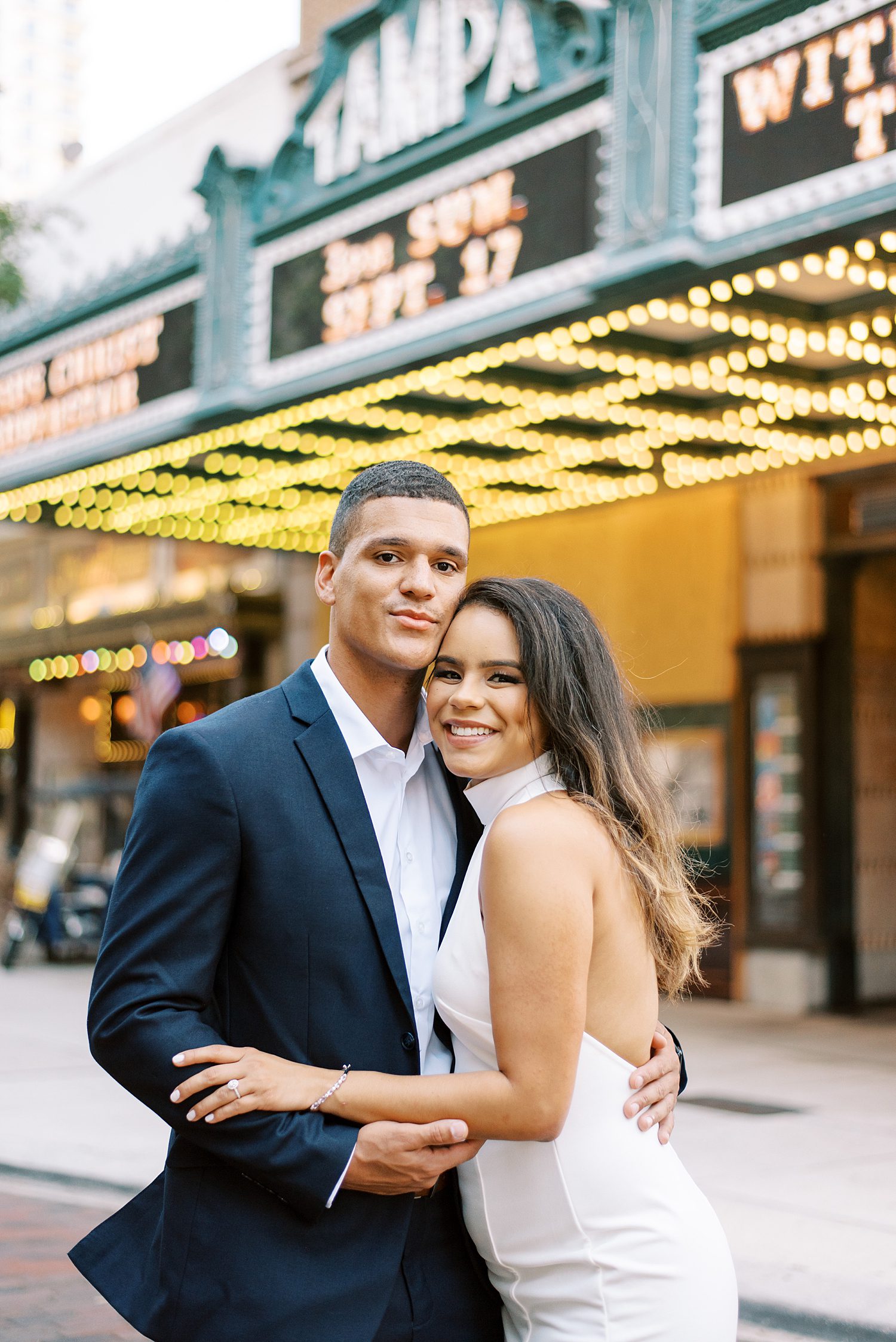 couple hugs in front of marquees in Downtown Tampa FL