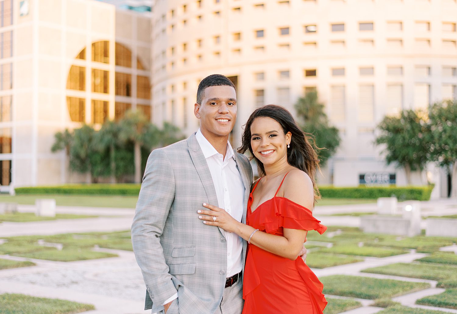 woman in red dress hugs man in grey suit iat Curtis Hixon Park