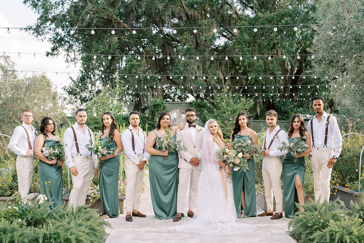 newlyweds pose with wedding party in garden at Mill Pond Estate