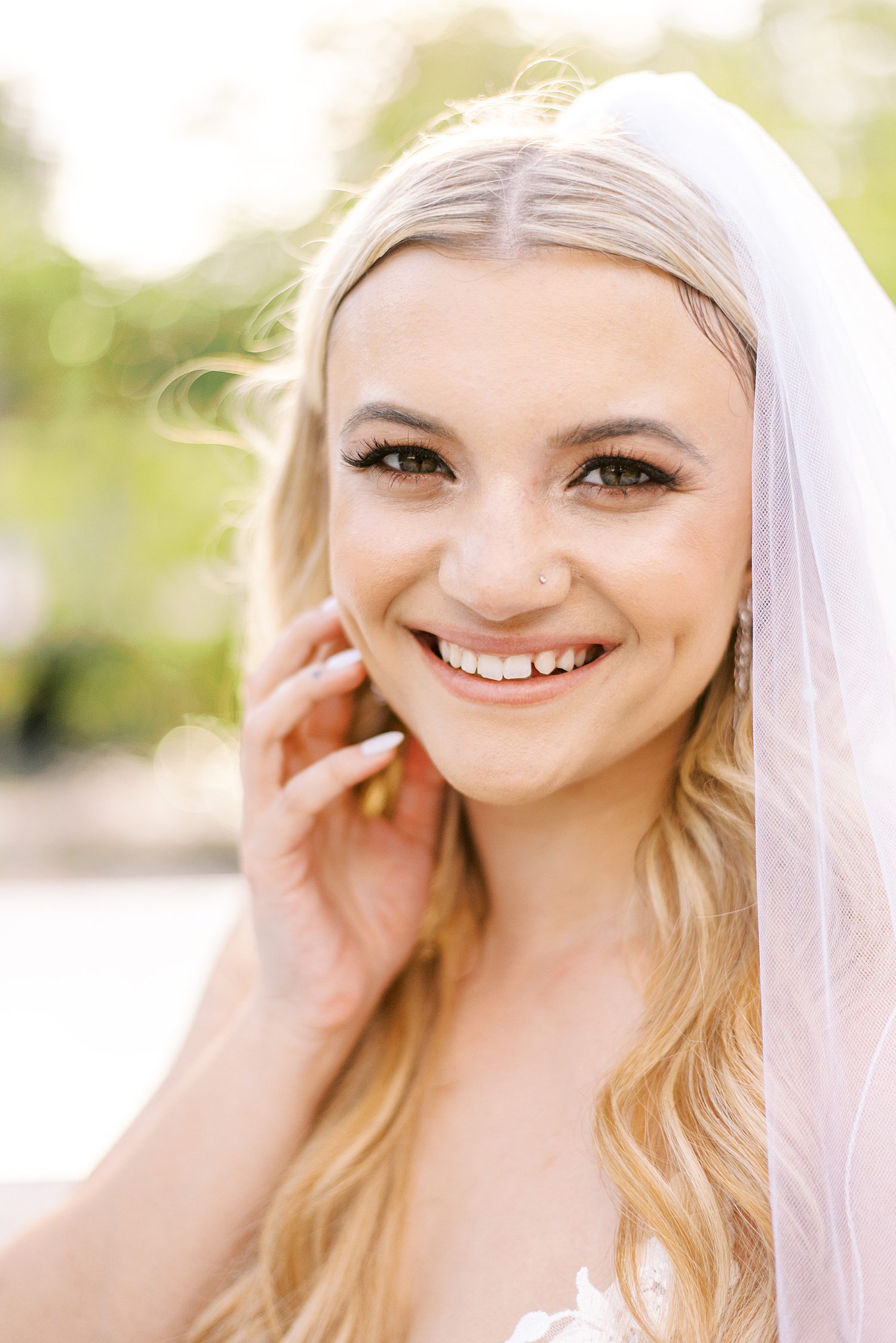 blonde woman smiles with veil around shoulders 