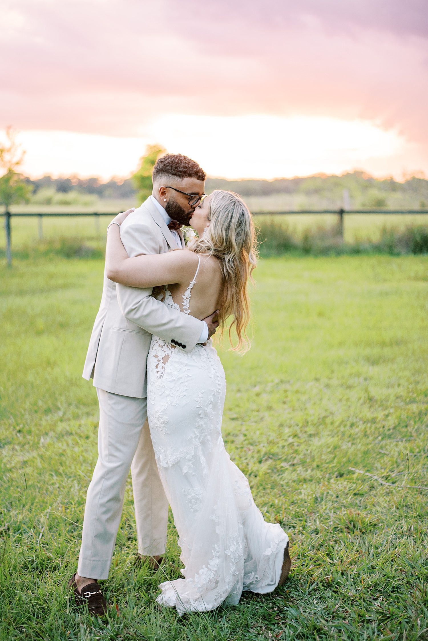 bride and groom kiss at sunset on lawn at Mill Pond Estate