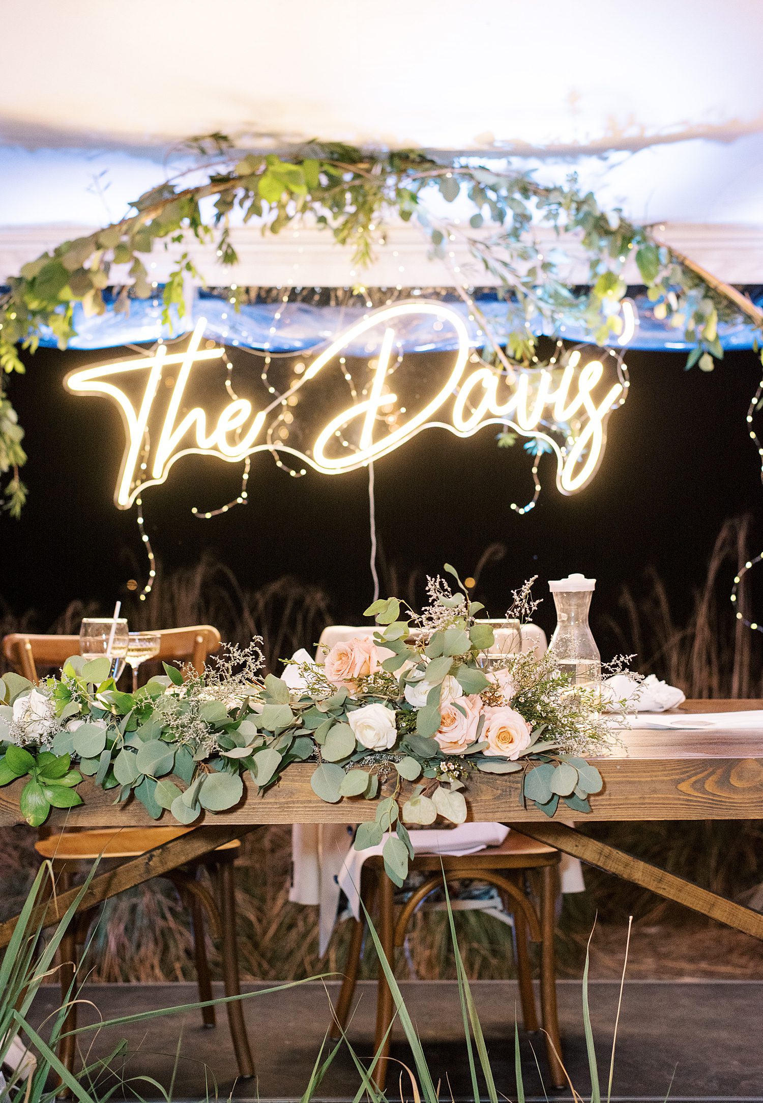 neon sign hangs from arbor during tented reception at Mill Pond Estate