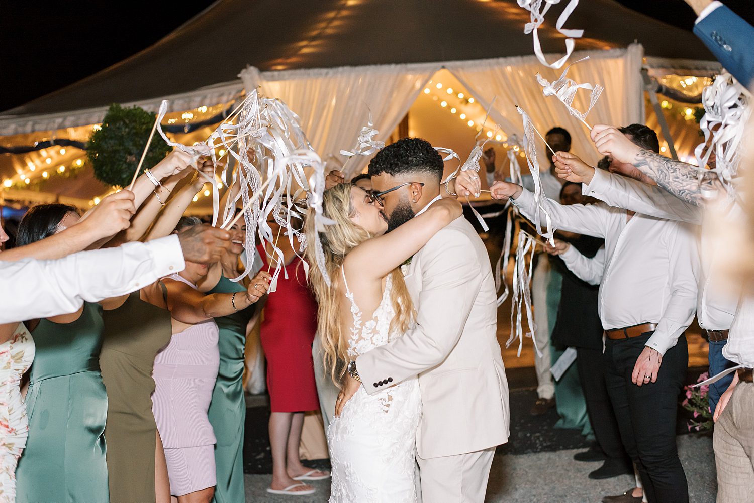 bride and groom kiss during ribbon exit from Tampa Bay FL wedding reception 
