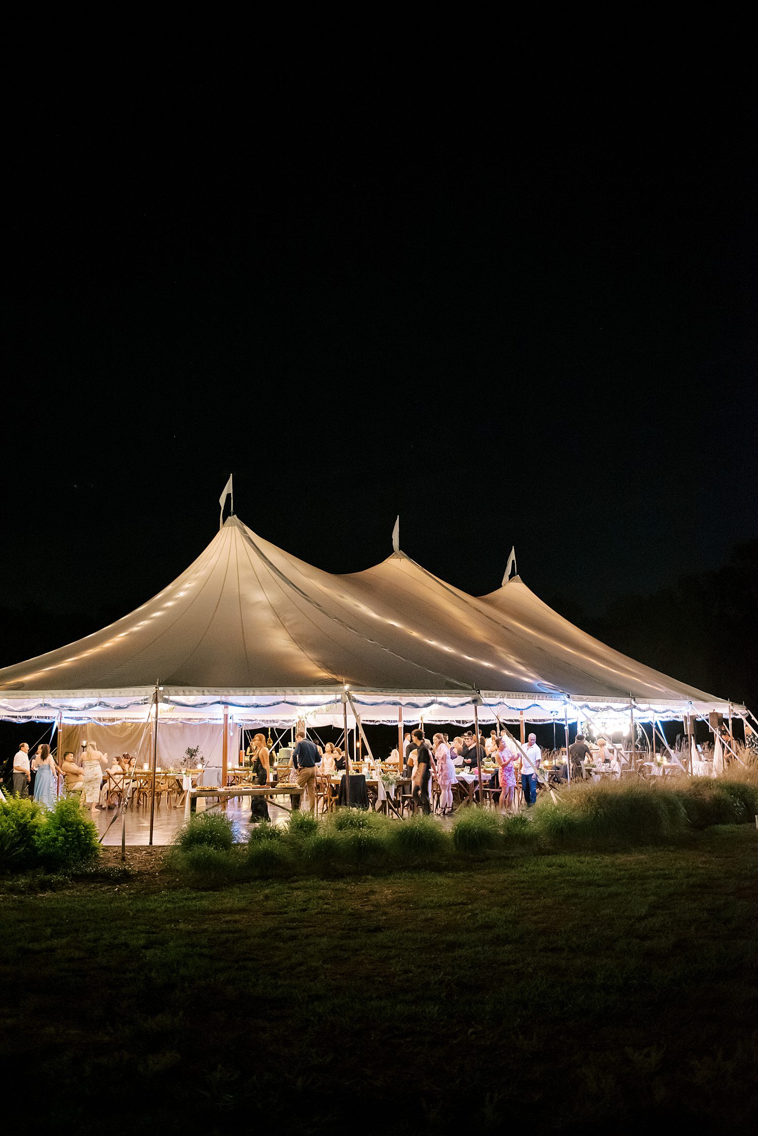 white tent lit up at night at Mill Pond Estate