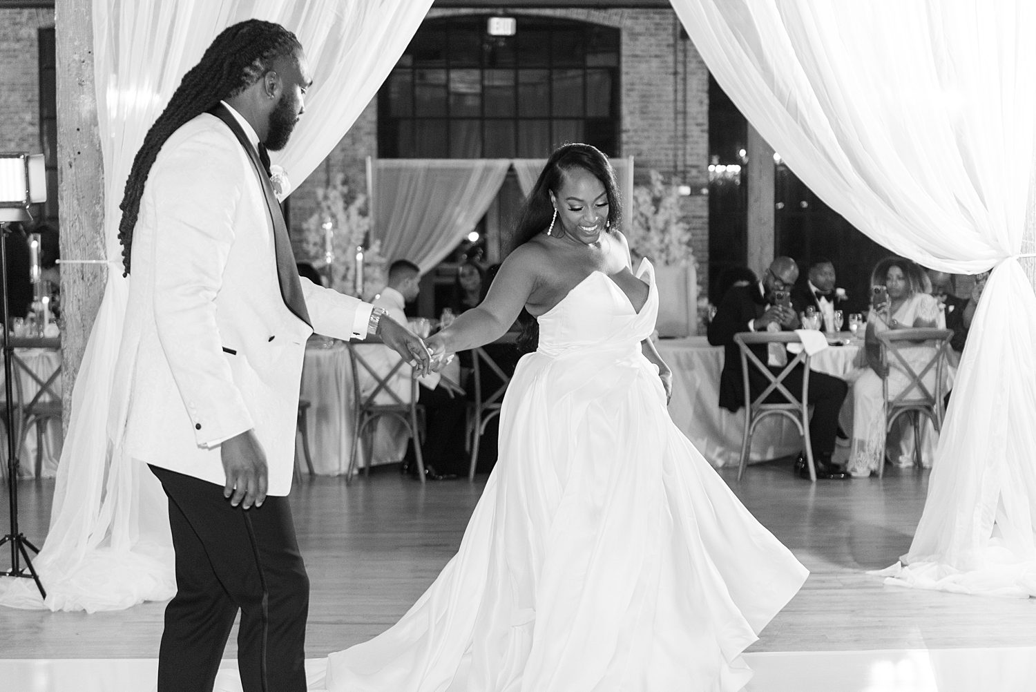 groom twirls out bride on dance floor at The Bibb Mill Event Center 