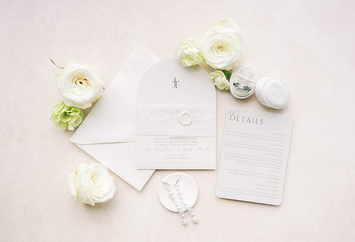 ivory stationery set sits with white flowers and ring box at The Bibb Mill Event Center