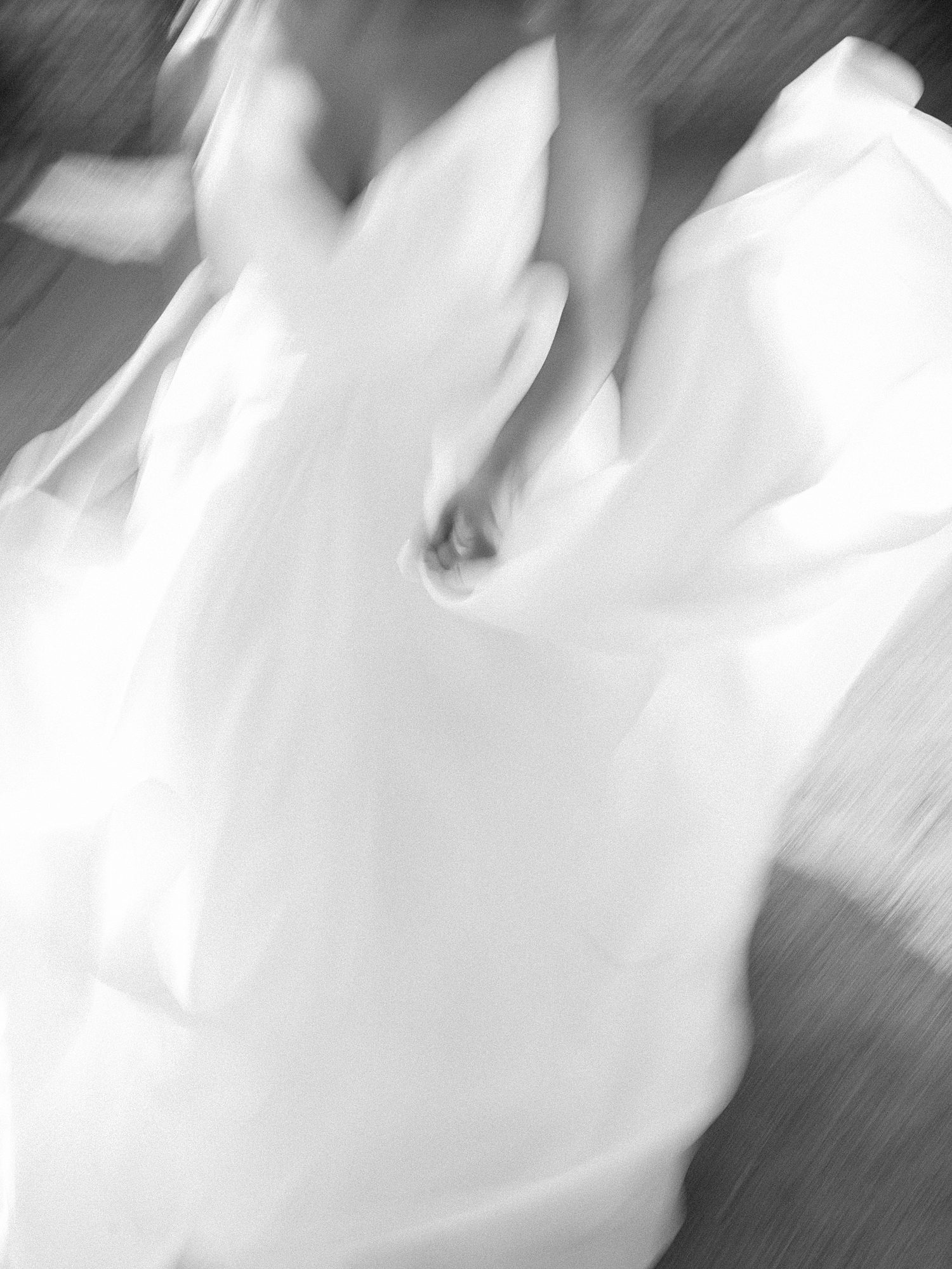 black and white portrait of bride twirling in wedding dress