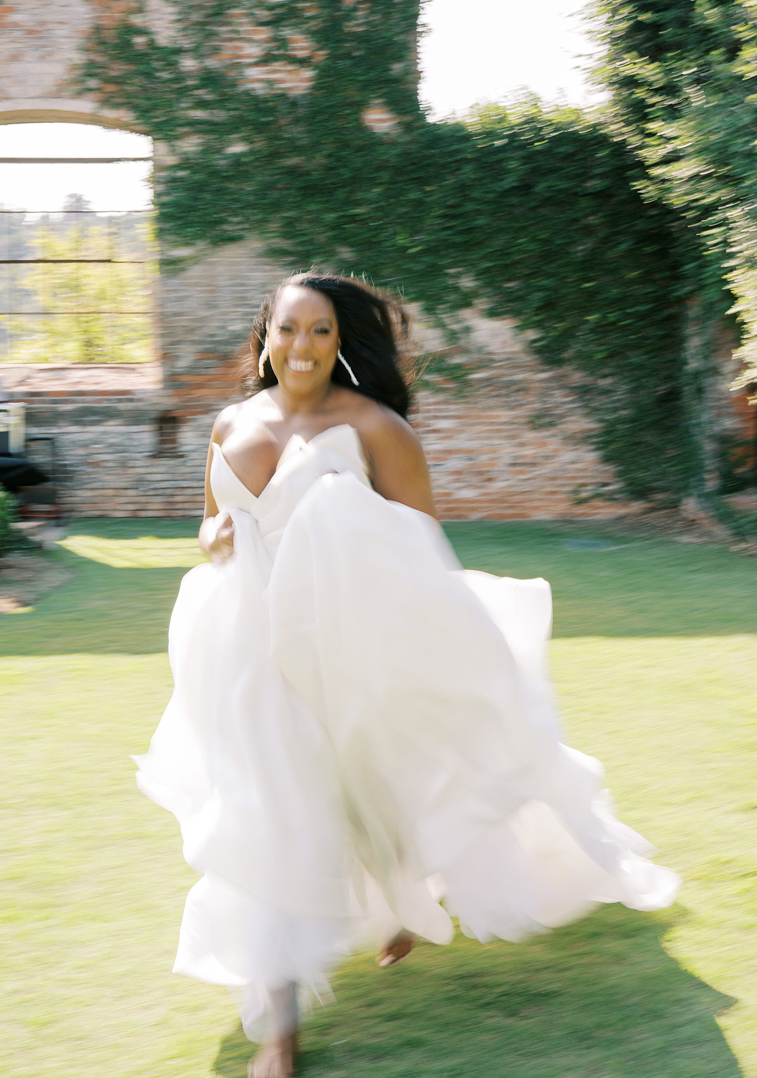 bride runs in wedding dress across lawn at The Bibb Mill Event Center