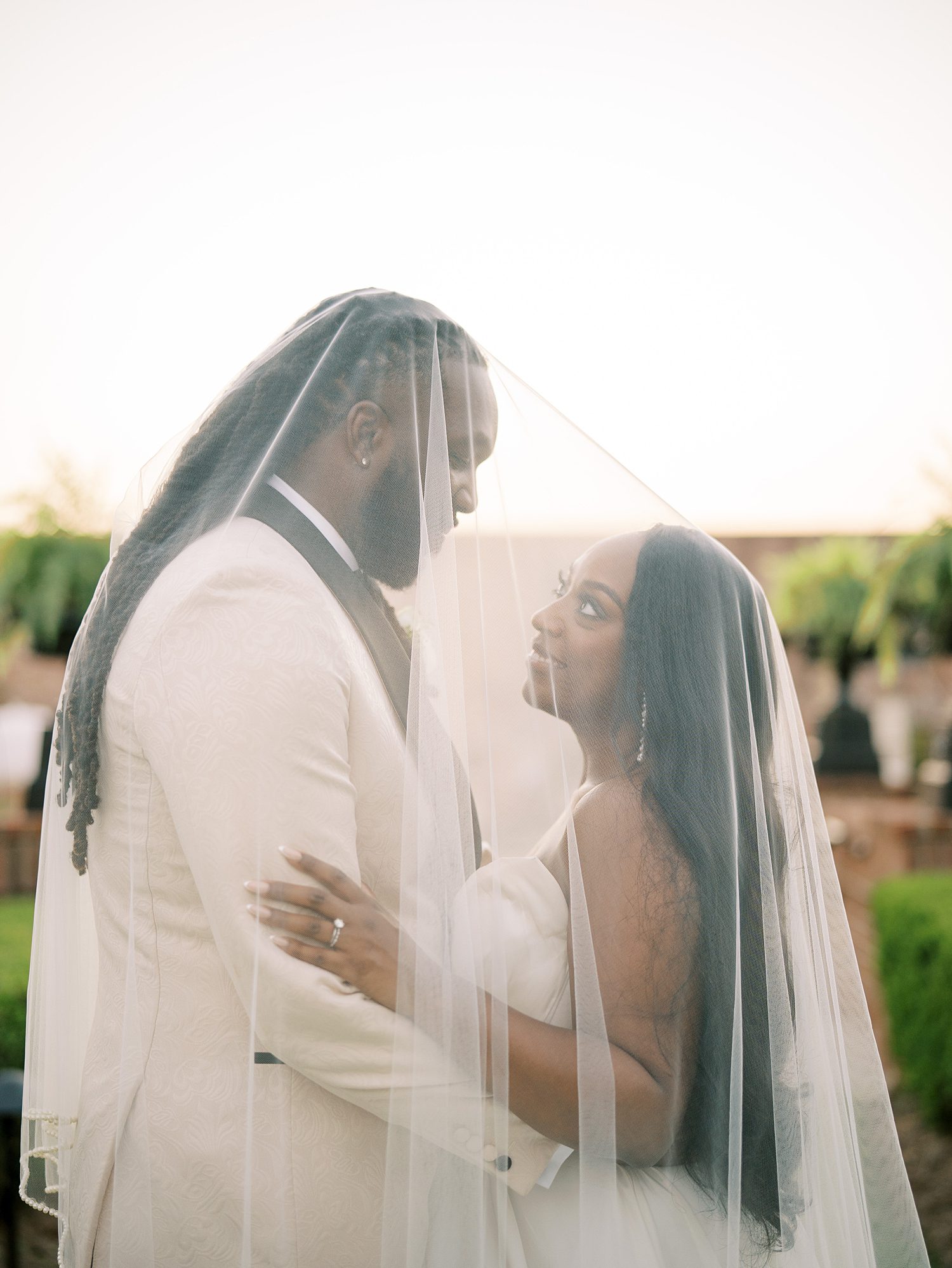 bride and groom hug under veil at The Bibb Mill Event Center