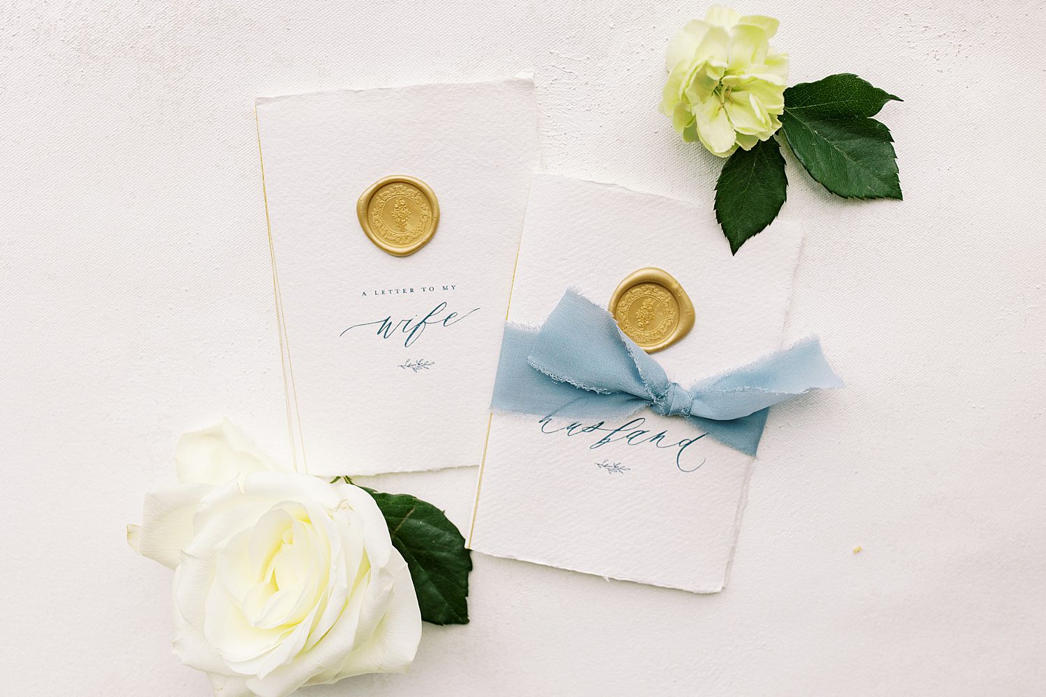vow booklets with gold wax seals and blue ribbons