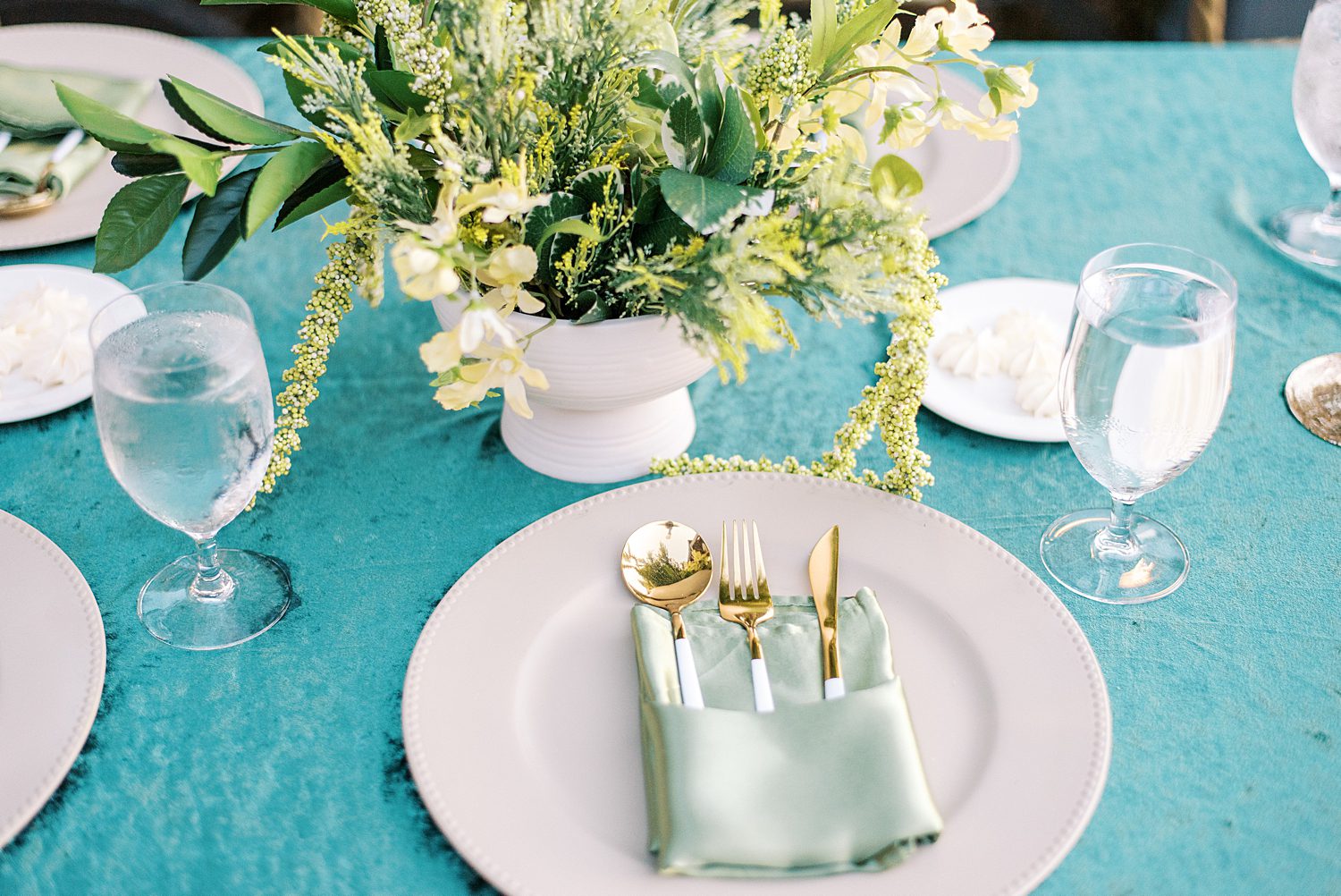 place setting on teal table cloth with mint napkins at The Bibb Mill Event Center
