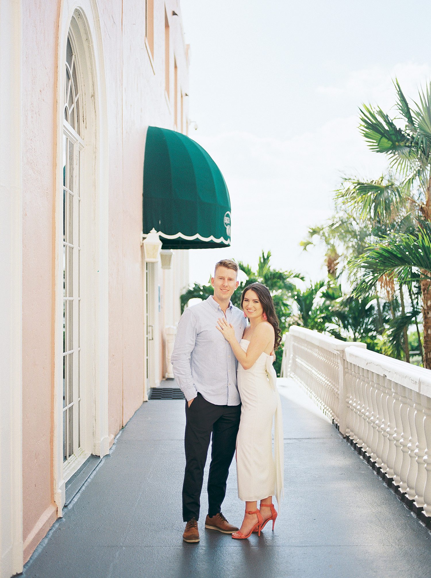 woman hugs fiancee placing hand on his chest outside The Don Cesar Hotel 