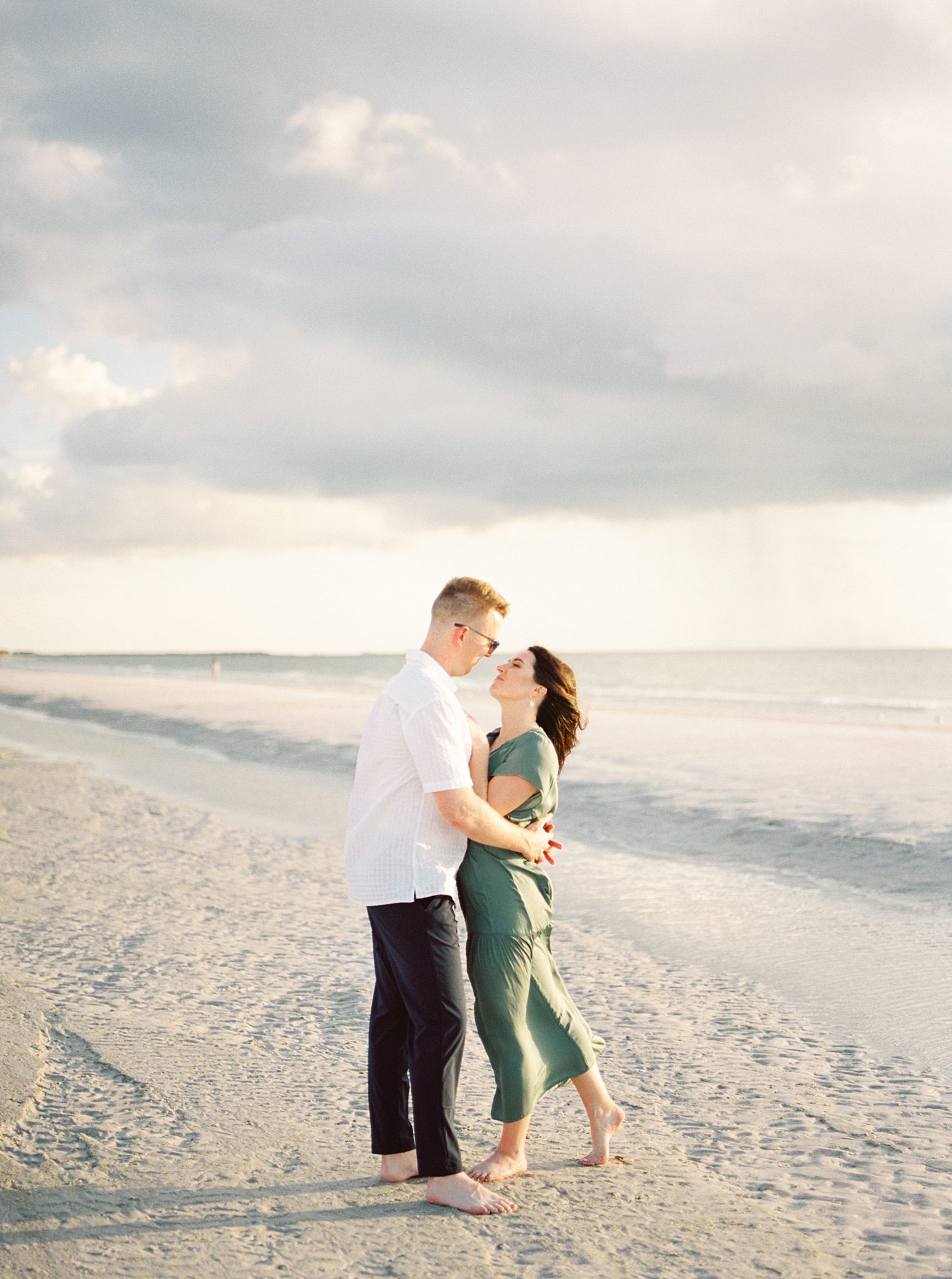 engaged couple hugs at sunset on beach in Tampa FL