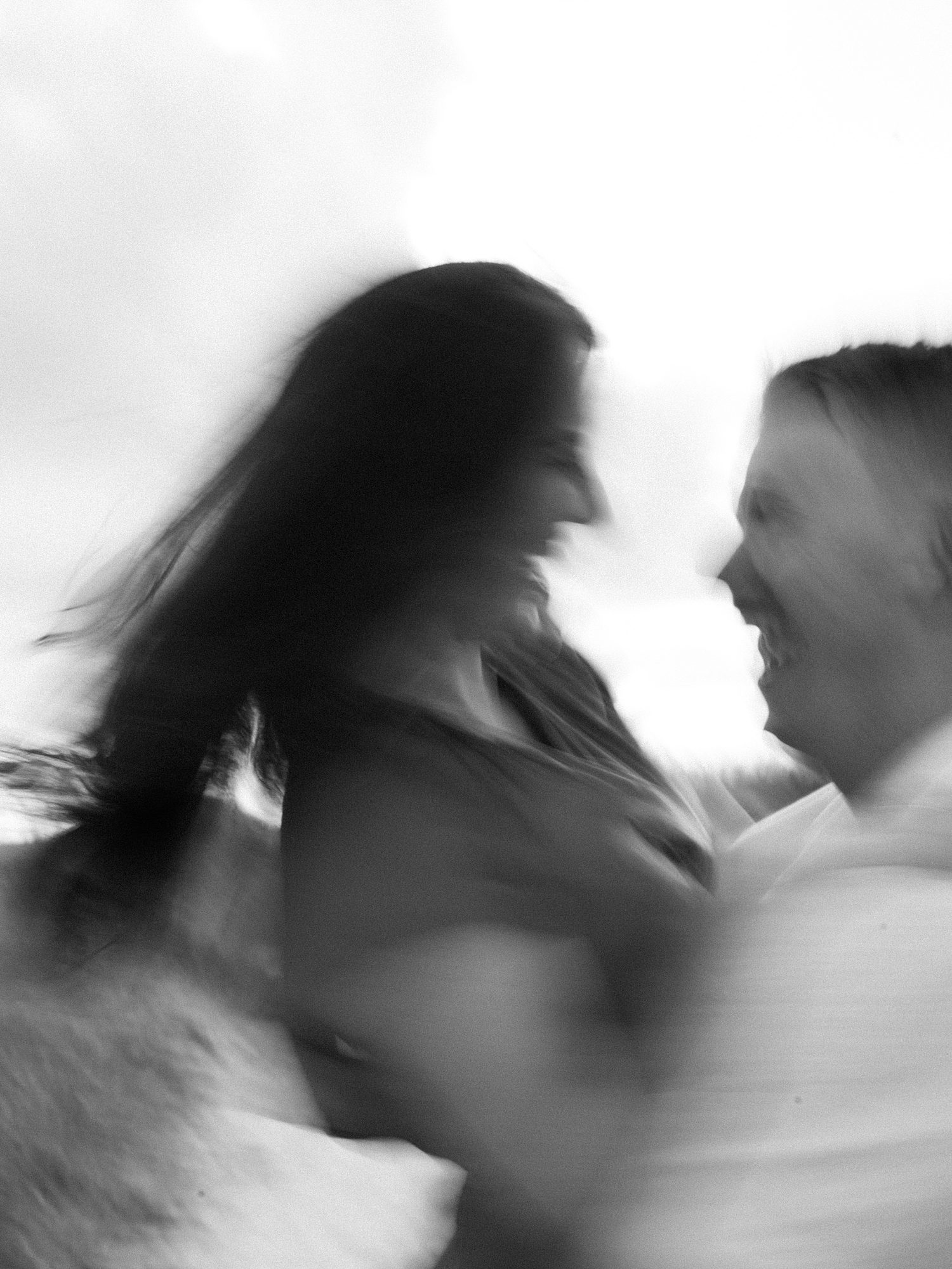 blurry film photo of man twirling woman on beach