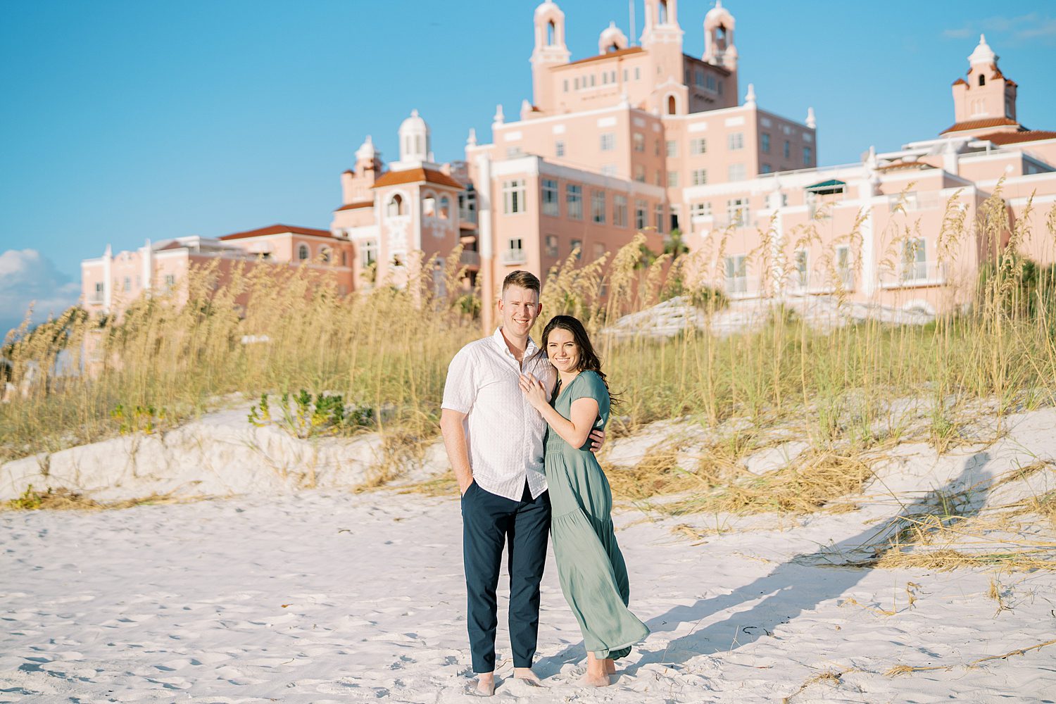 couple stands on Tampa beach in front of the Don Cesar Hotel