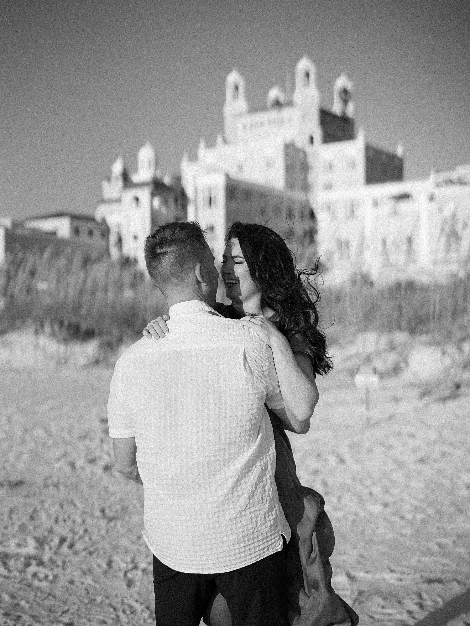 black and white photo of couple on beach in front of the Don Cesar Hotel