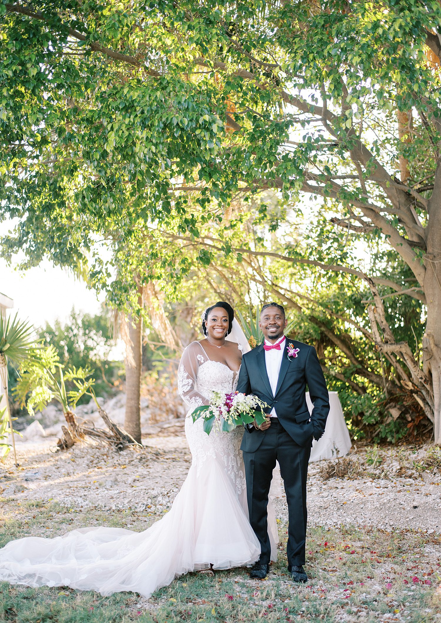 newlyweds stand together under trees in Tampa FL