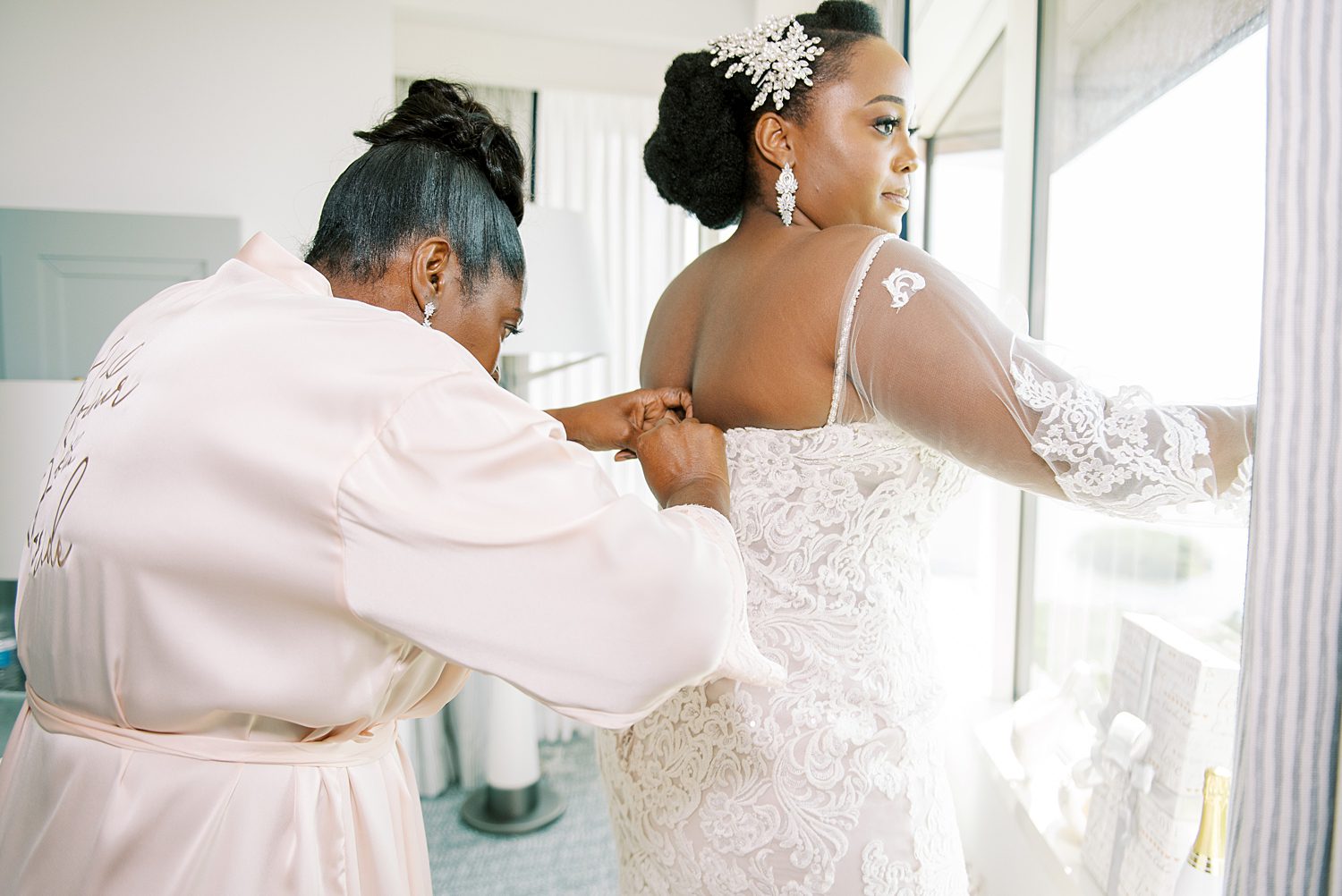 mother helps bride into wedding dress before Florida wedding 