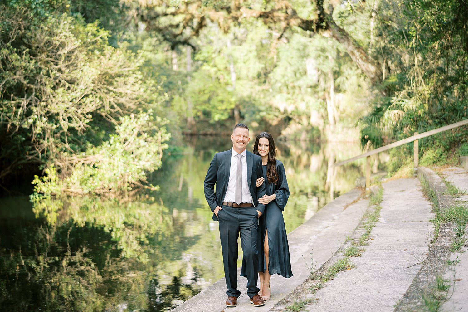 engaged couple holds hands on dusty path in Hillsborough River State Park