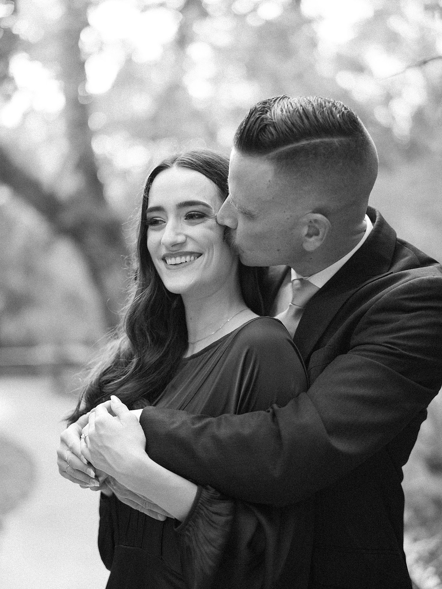 man hugs woman from behind during Hillsborough River State Park engagement session 