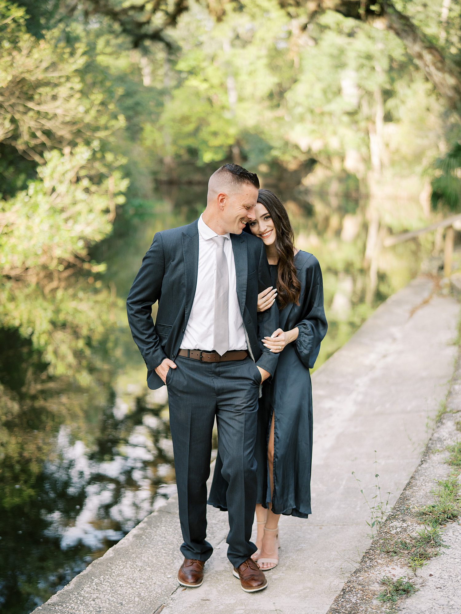 woman in teal dress leans head on man's shoulder in Hillsborough River State Park