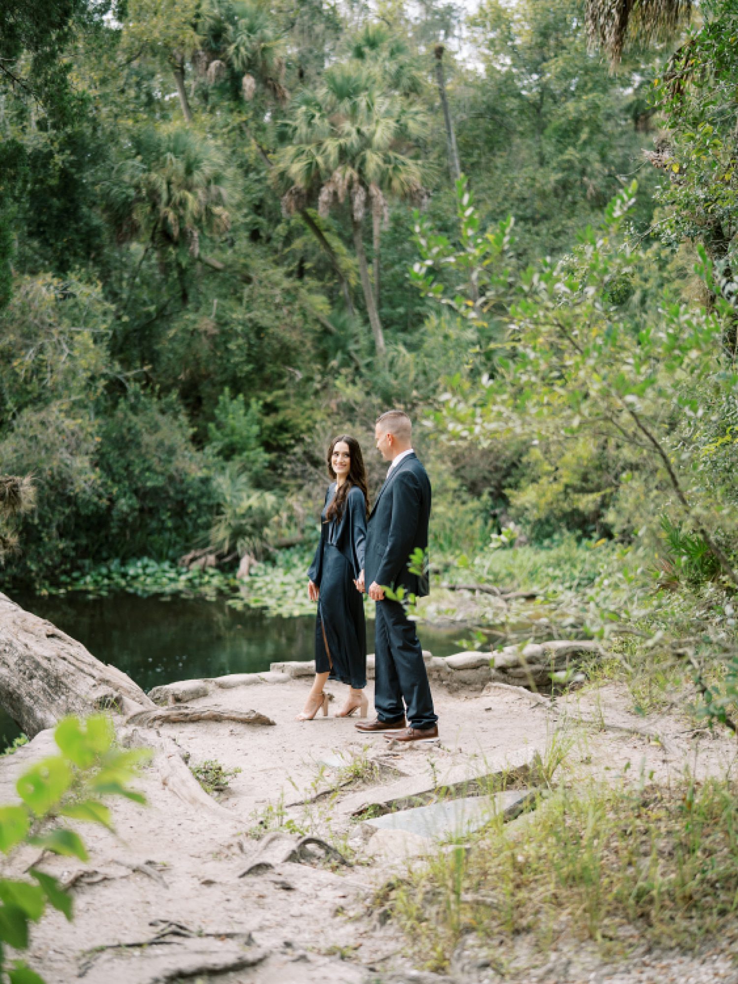 engaged couple walks by river inside Hillsborough River State Park