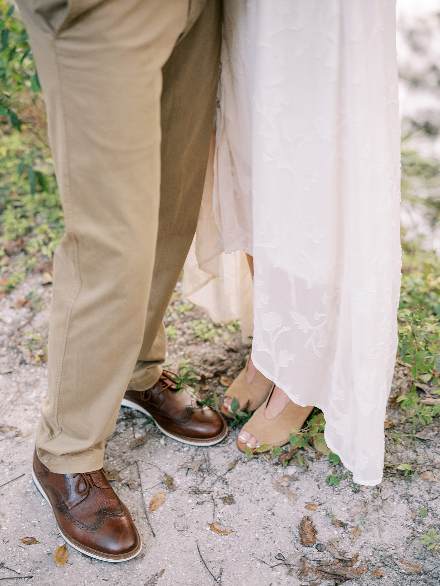 couple stands toe to toe in white linen dress 
