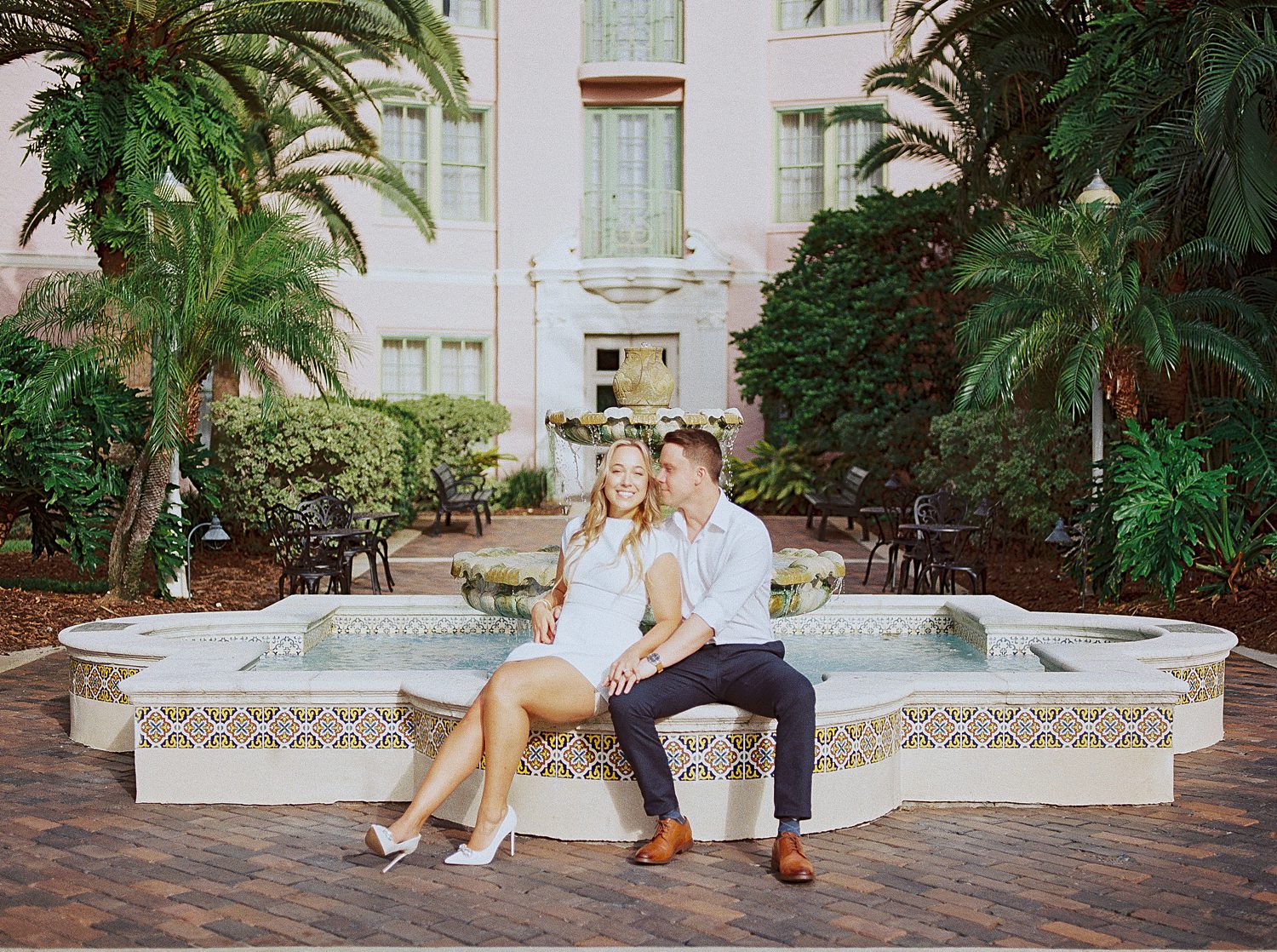 engaged couple sits on edge of fountain at the Tampa Museum of Fine Arts