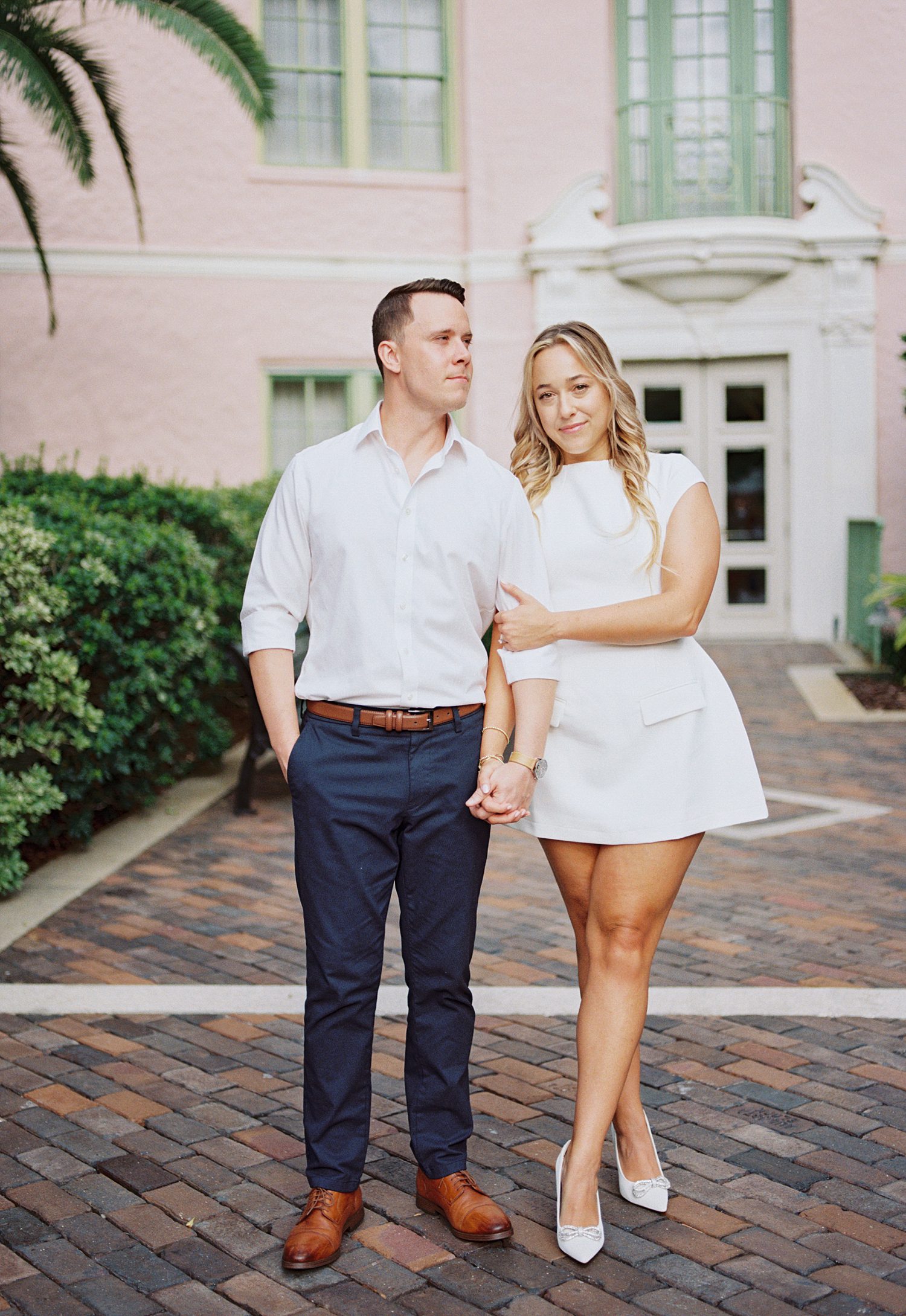 engaged couple walks in front of Tampa Museum of Fine Arts