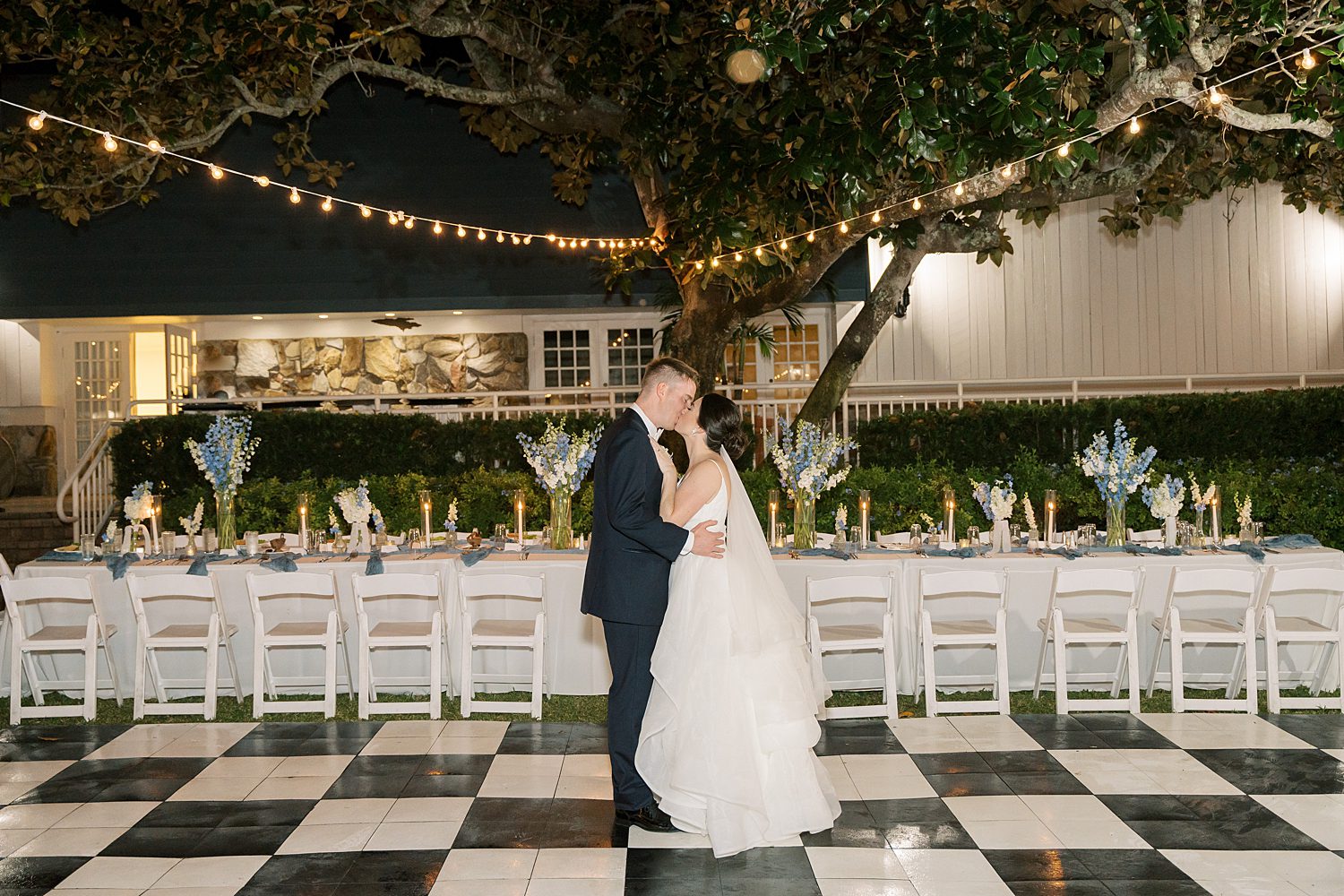 bride and groom hug on black and white dance floor during open air reception at Innisbrook Resort