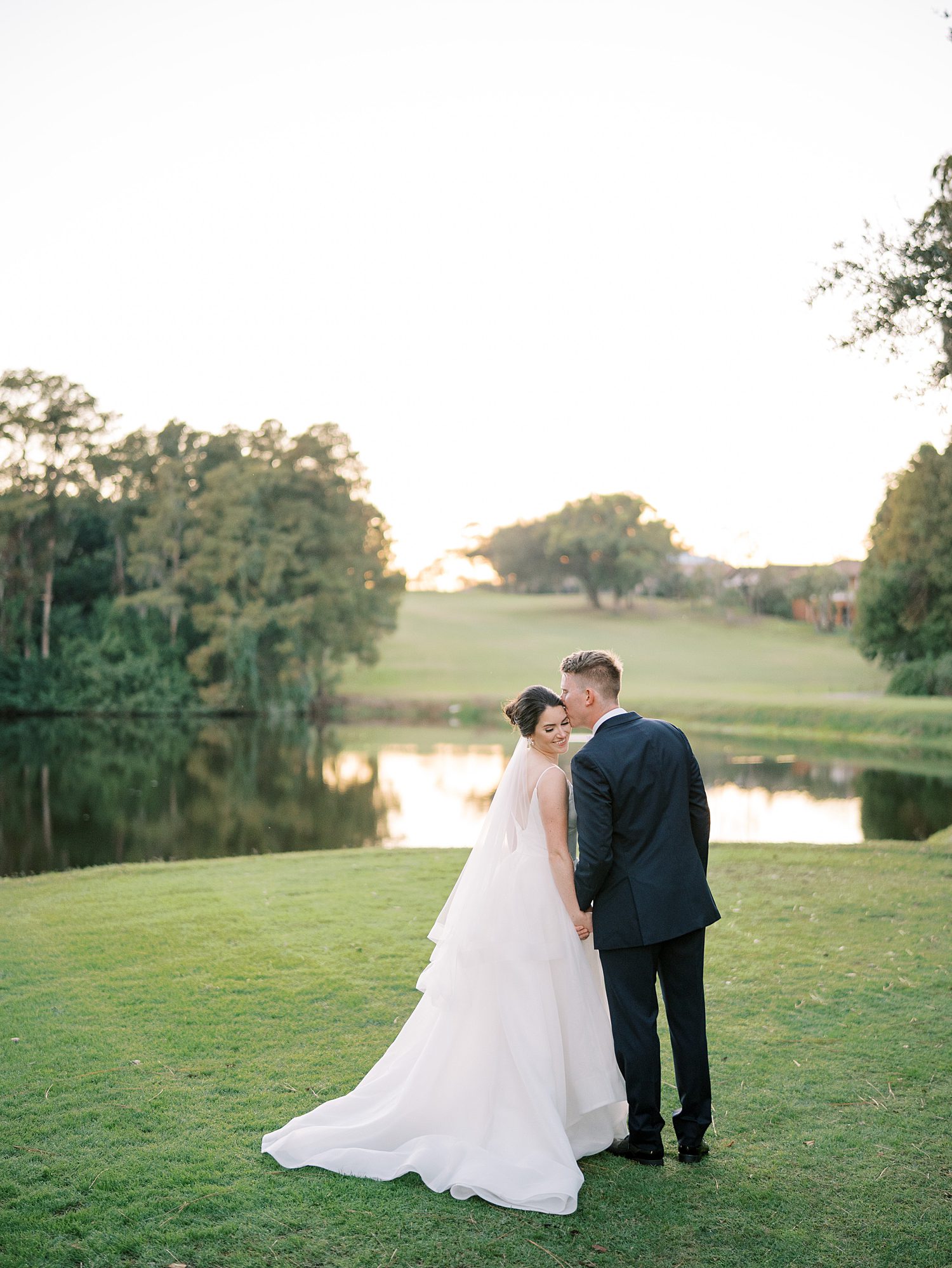 groom leans to kiss bride's forehead during Tampa FL wedding day