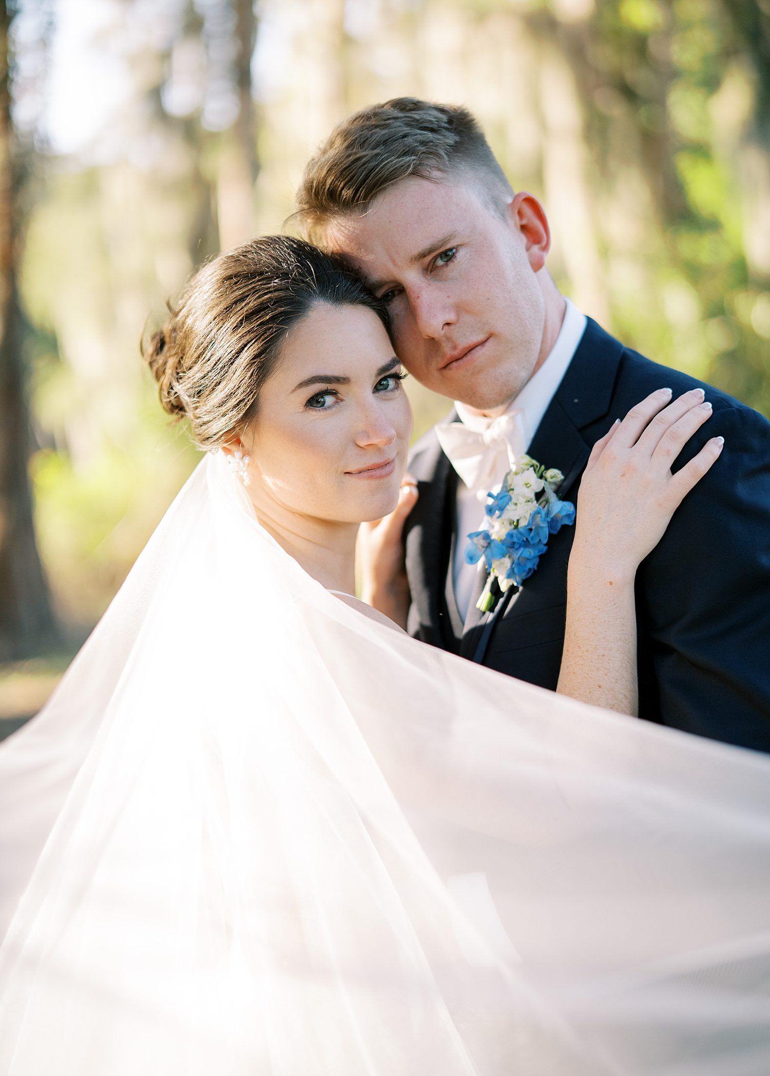 newlyweds lean heads together hugging during open air reception at Innisbrook Resort wedding