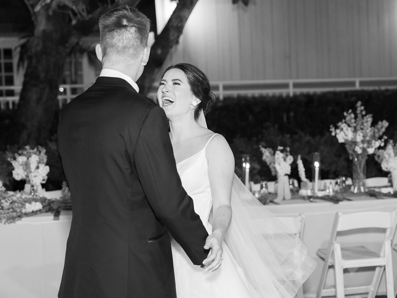 bride grins and smiles up at husband during dance at open air reception at Innisbrook Resort