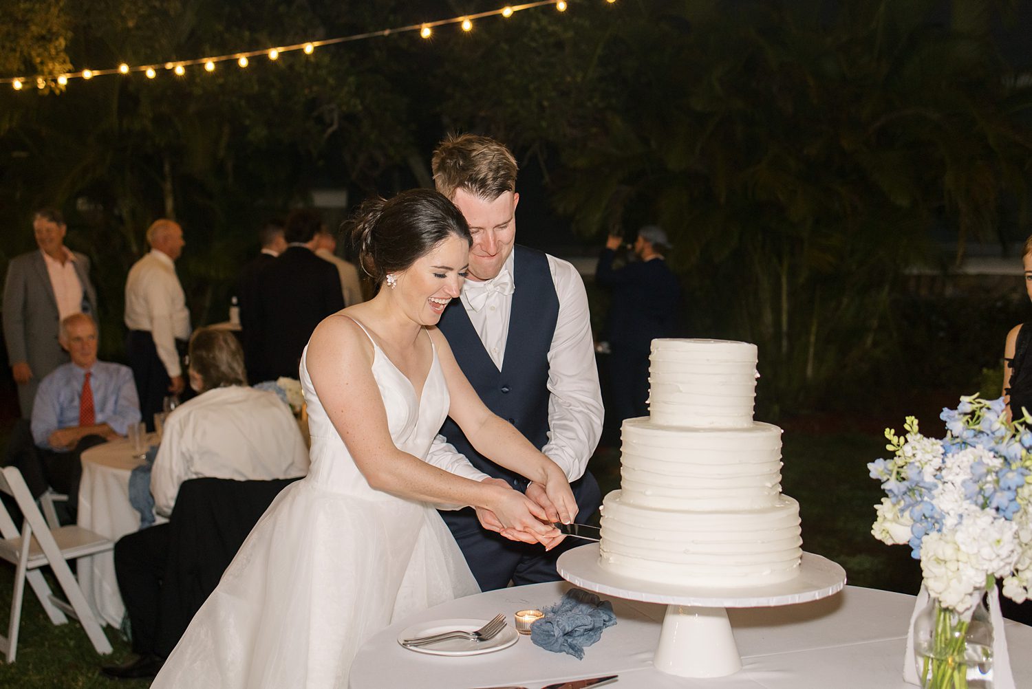 newlyweds cut wedding cake during open air reception at Innisbrook Resort