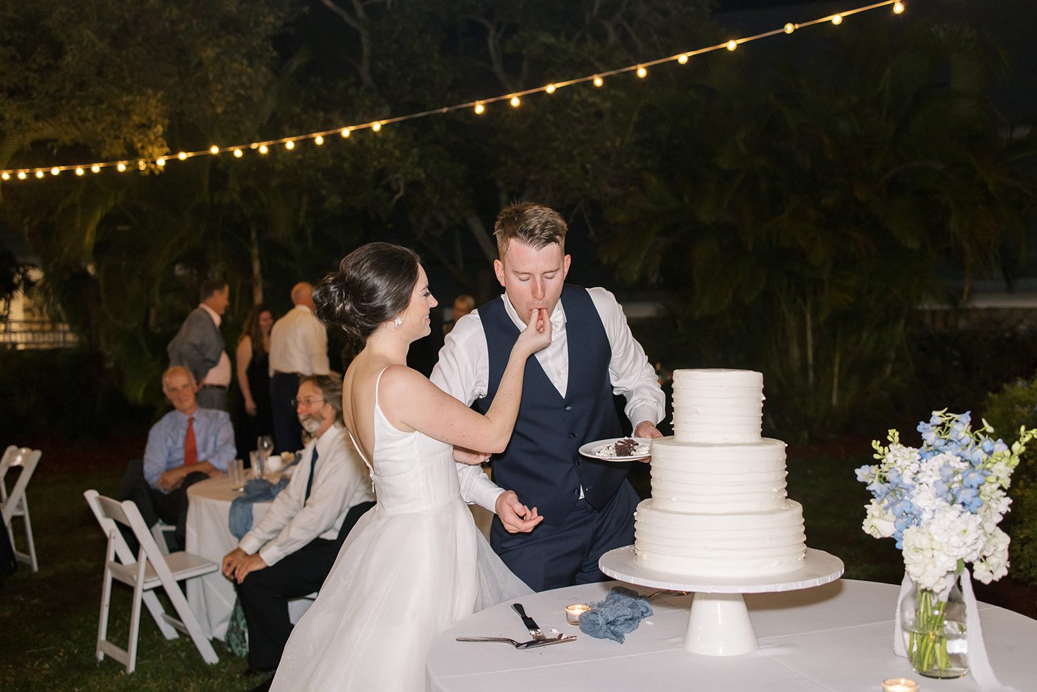 bride feeds groom cake during Tampa FL wedding reception