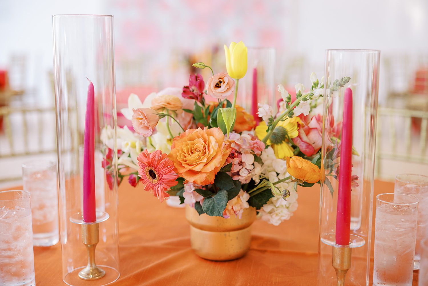 wedding reception centerpiece with pink taper candles and colorful flowers 