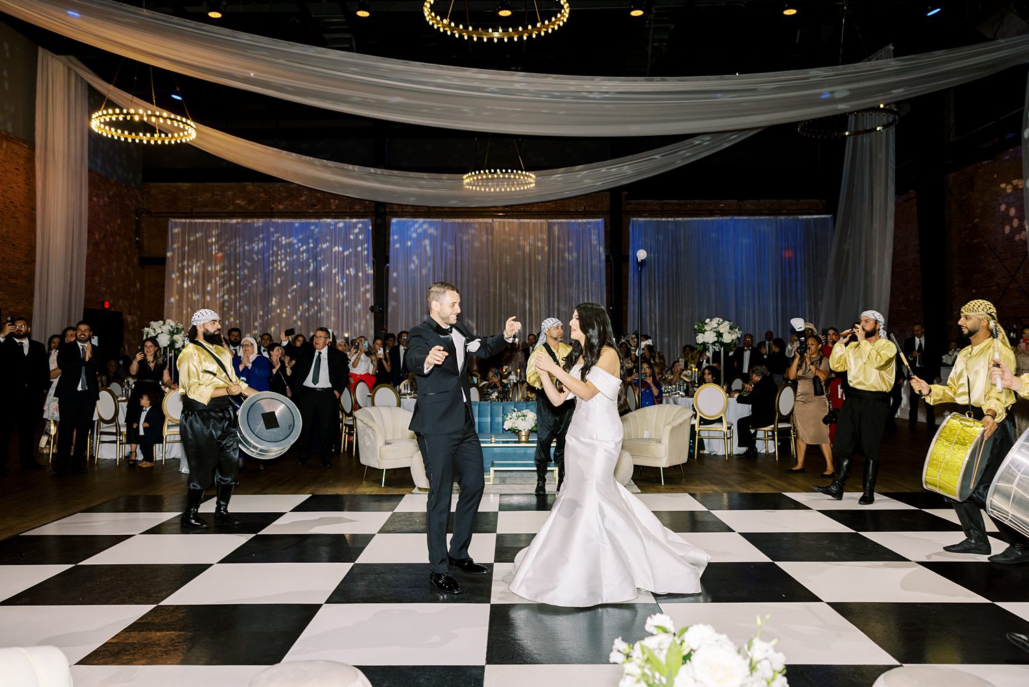 bride and groom dance on black and white tiled floor at Armature Works 