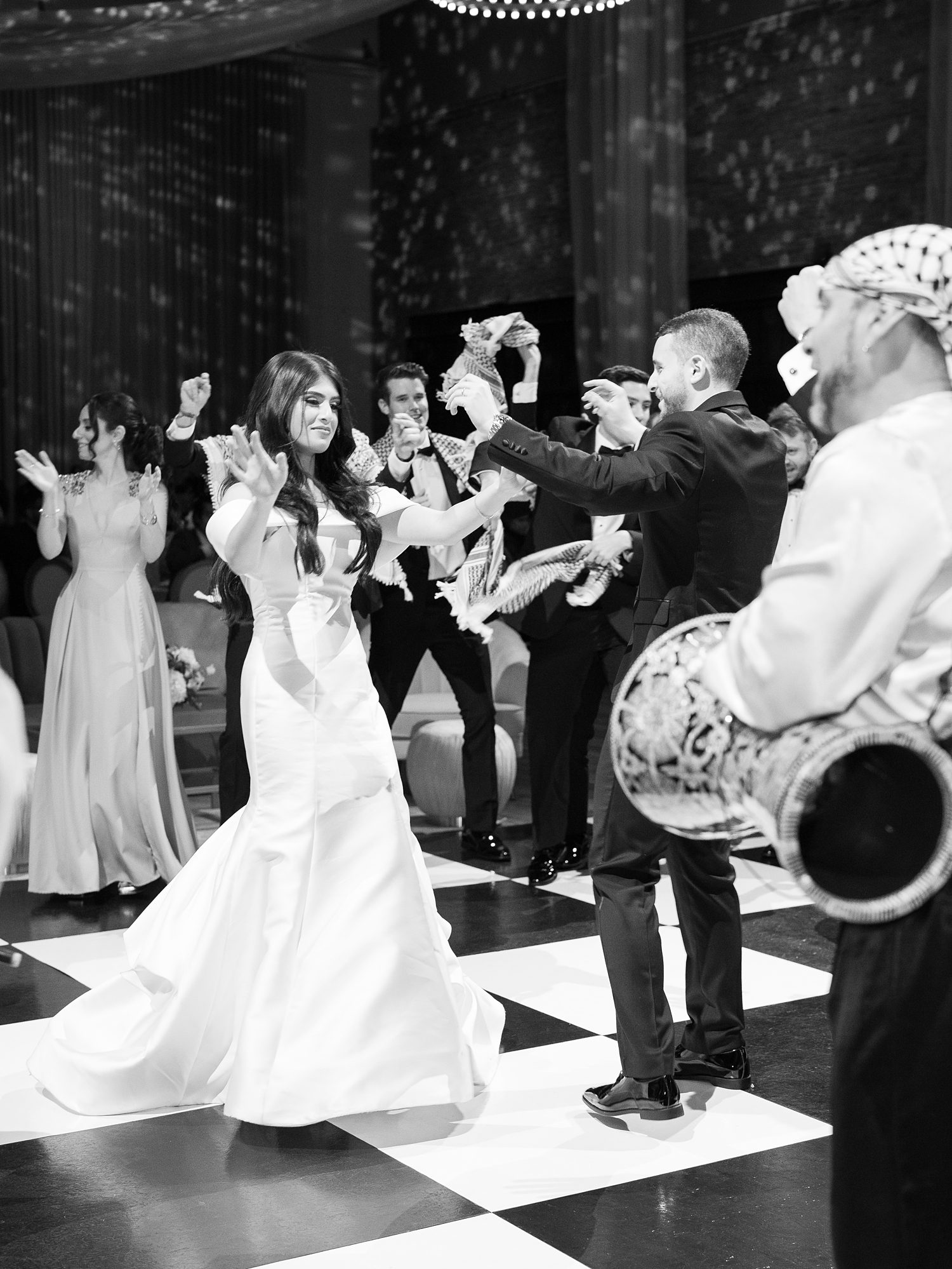 bride and groom dance with band around them on floor at Armature Works 