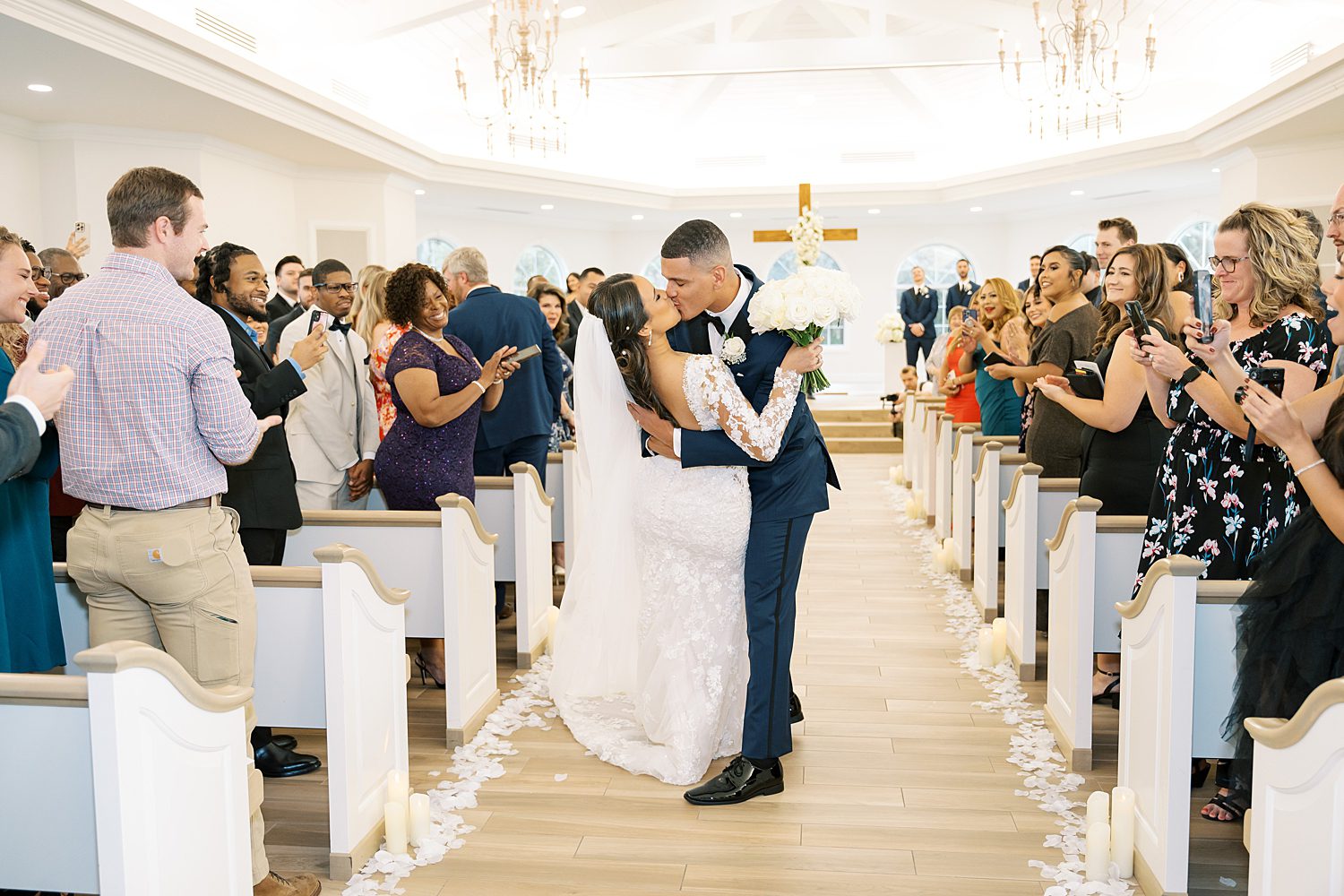 bride and groom kiss in aisle after recessional from ceremony at Harborside Chapel in Tampa FL