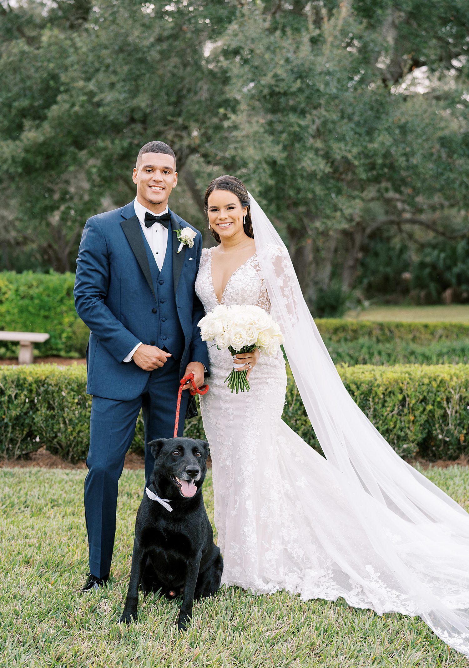 bride and groom pose with black dog in Tampa FL