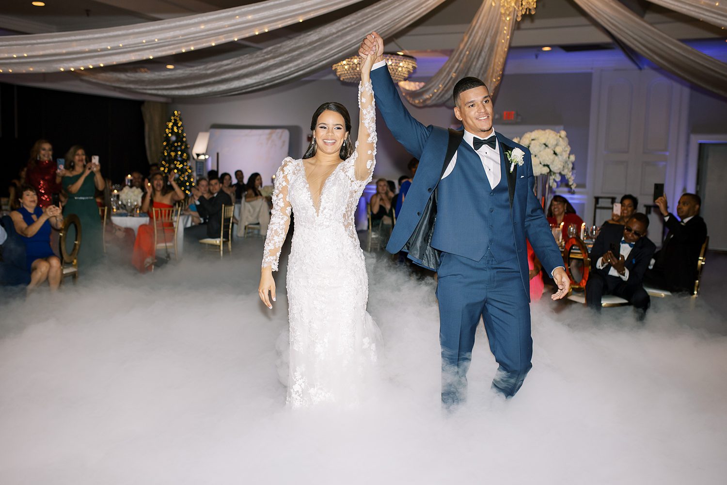 newlyweds cheer walking onto dance floor in fog at their Rusty Pelican Tampa wedding reception 