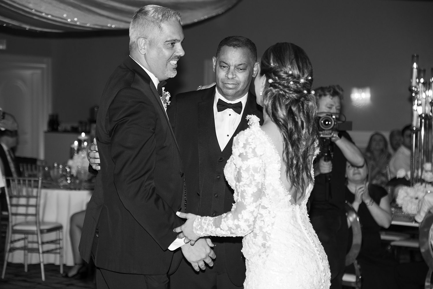 bride dances with father  and stepfather during Rusty Pelican Tampa wedding reception