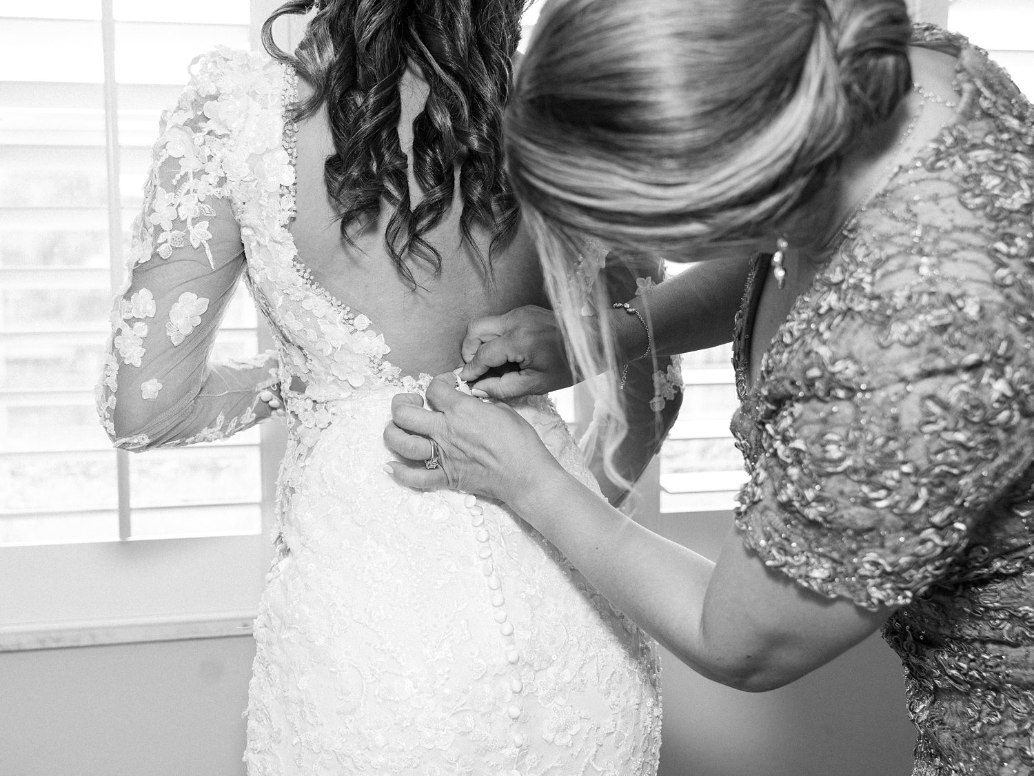 mother adjusts buttons on bride's wedding gown for Tampa FL wedding day