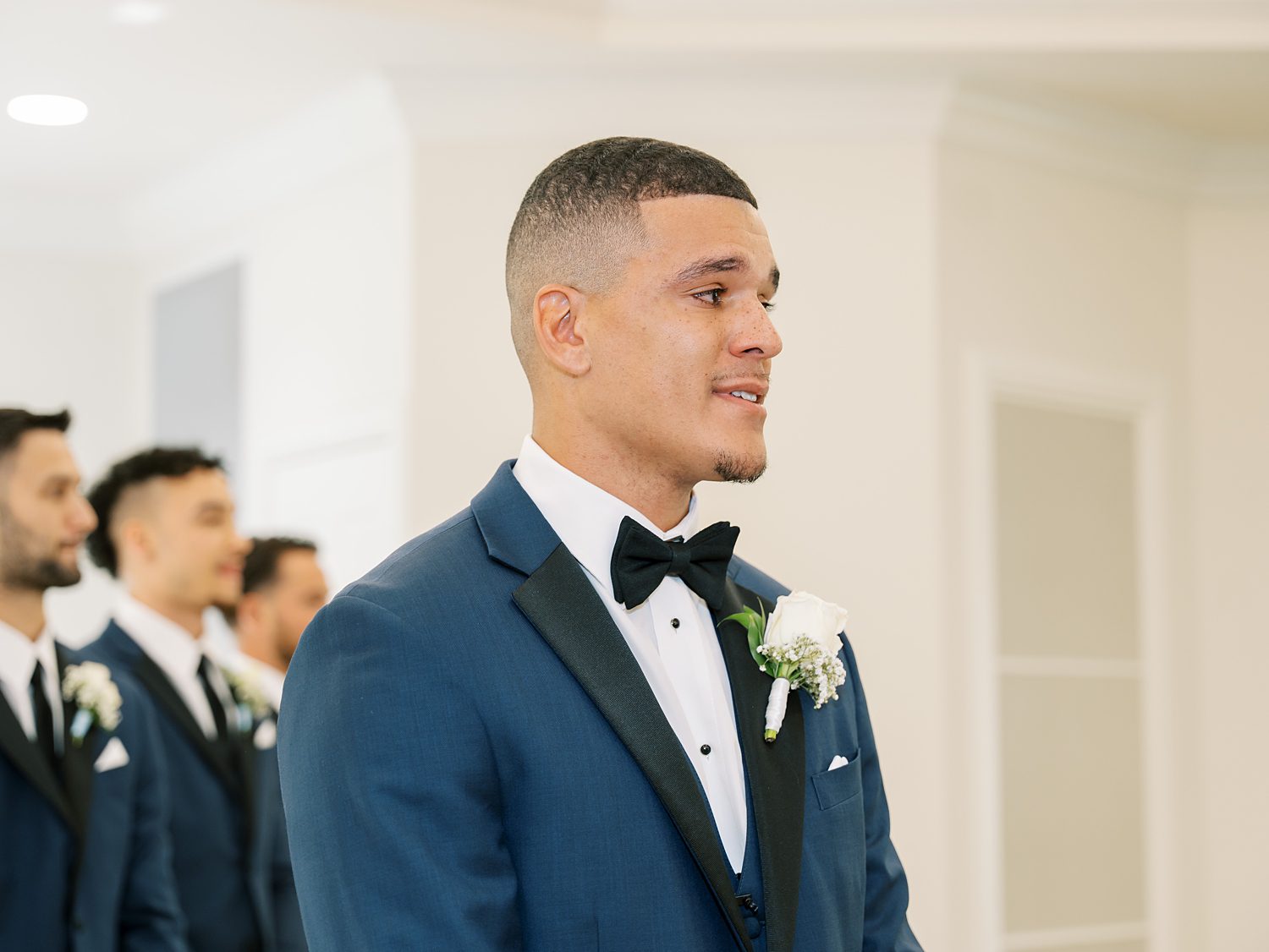 groom in navy suit with black lapels tears up during ceremony at Harborside Chapel in Tampa FL