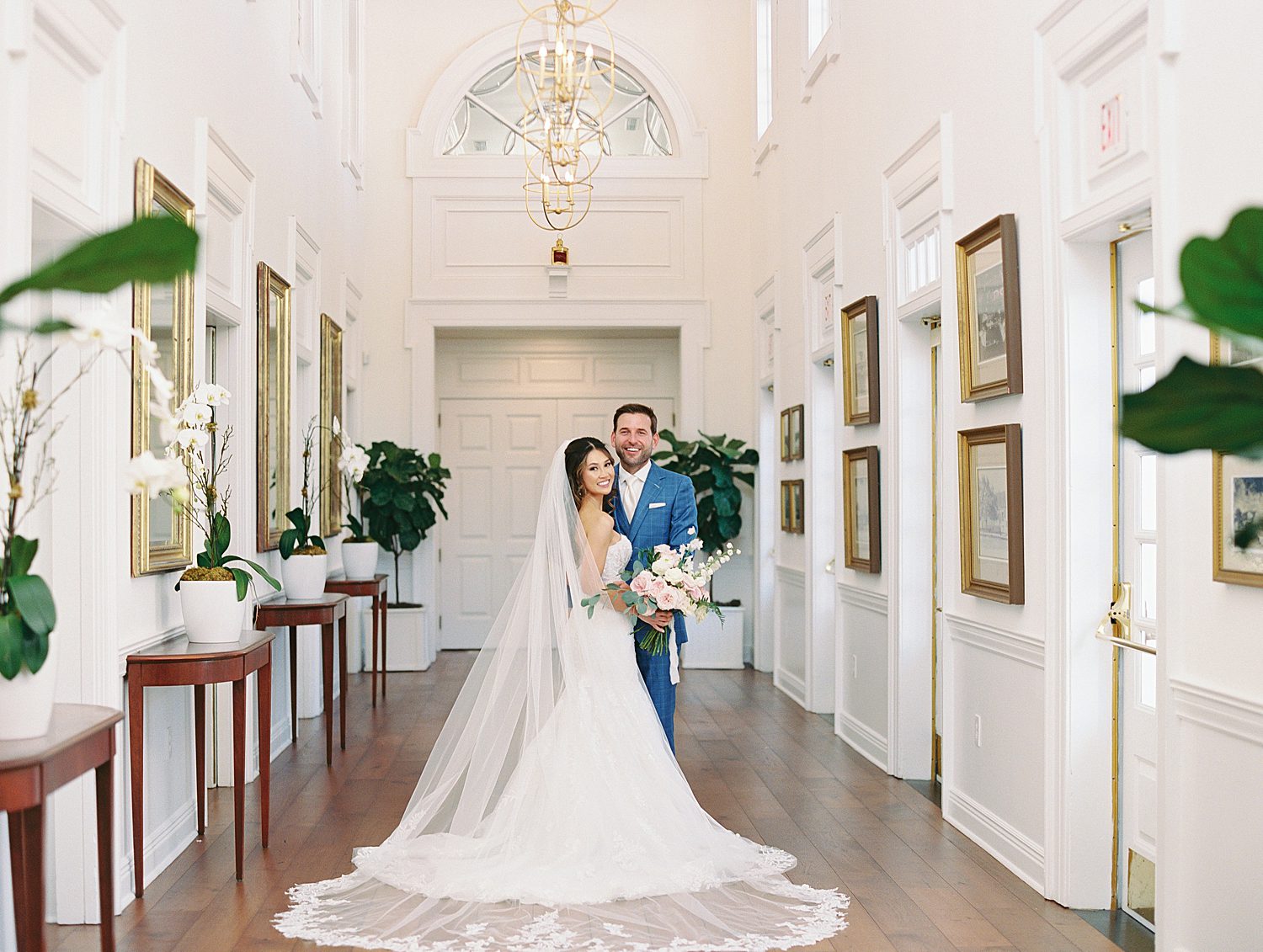 bride and groom hug in hallway of Tampa Yacht Club