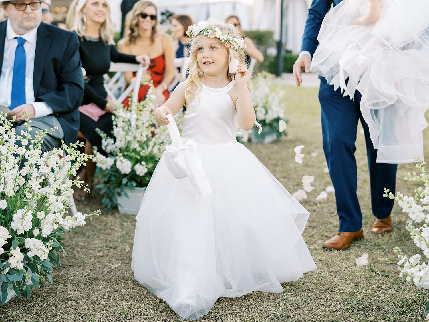 flower girl in white dress walks down aisle at Tampa Yacht Club