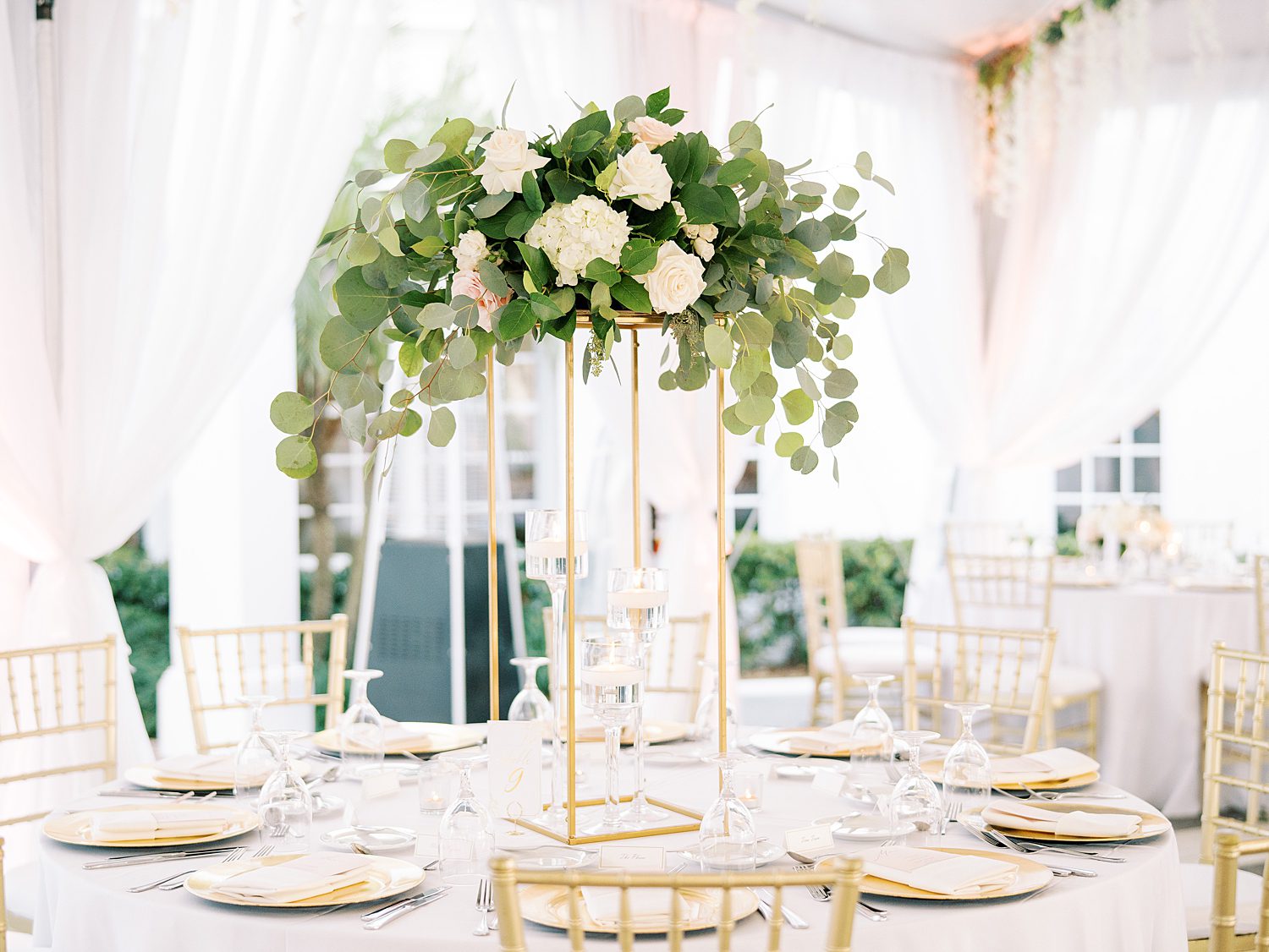 wedding reception with tall floral arrangements and gold chargers and vase at Tampa Yacht Club