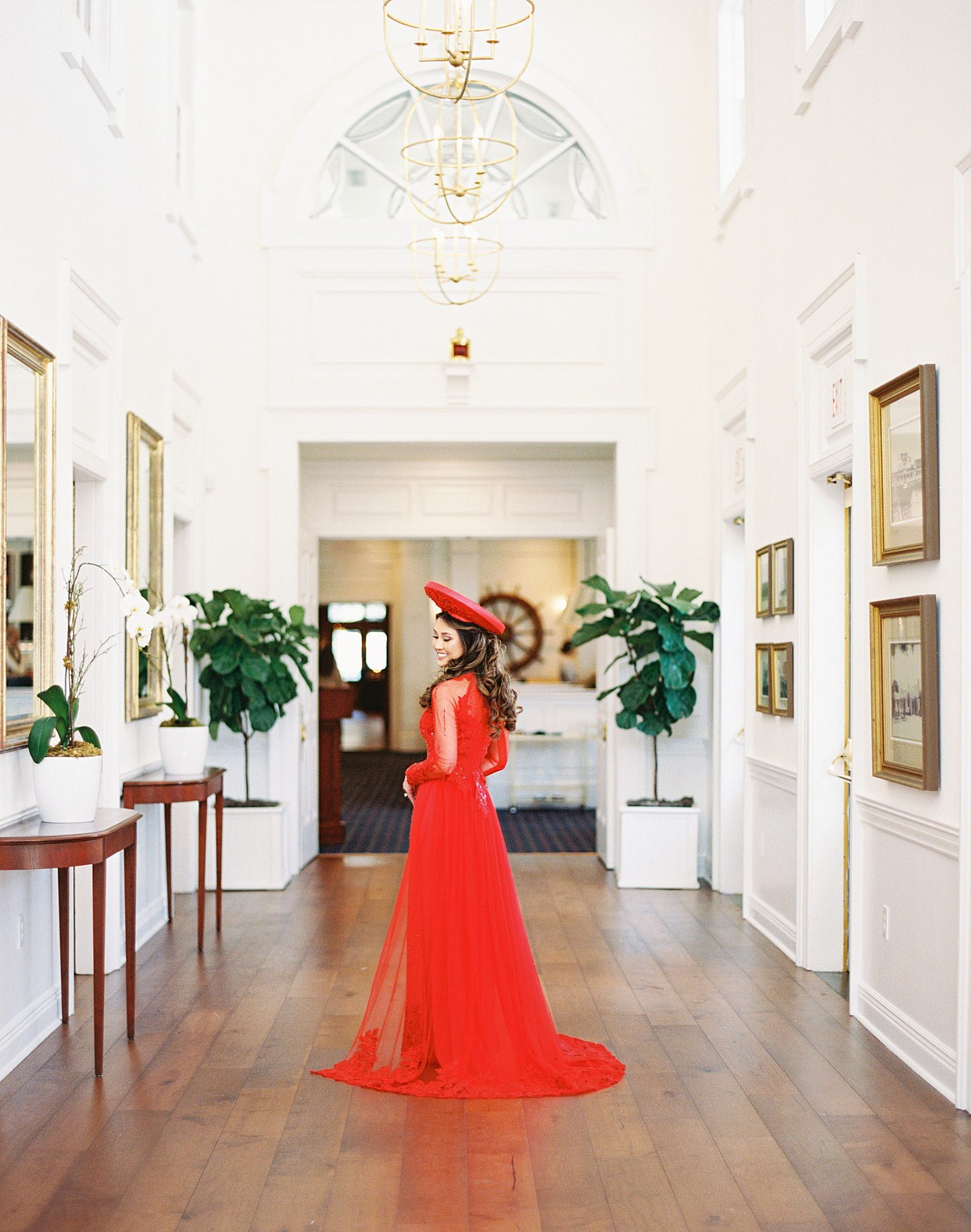 bride in traditional red Vietnamese wedding dress poses inside the Tampa Yacht Club