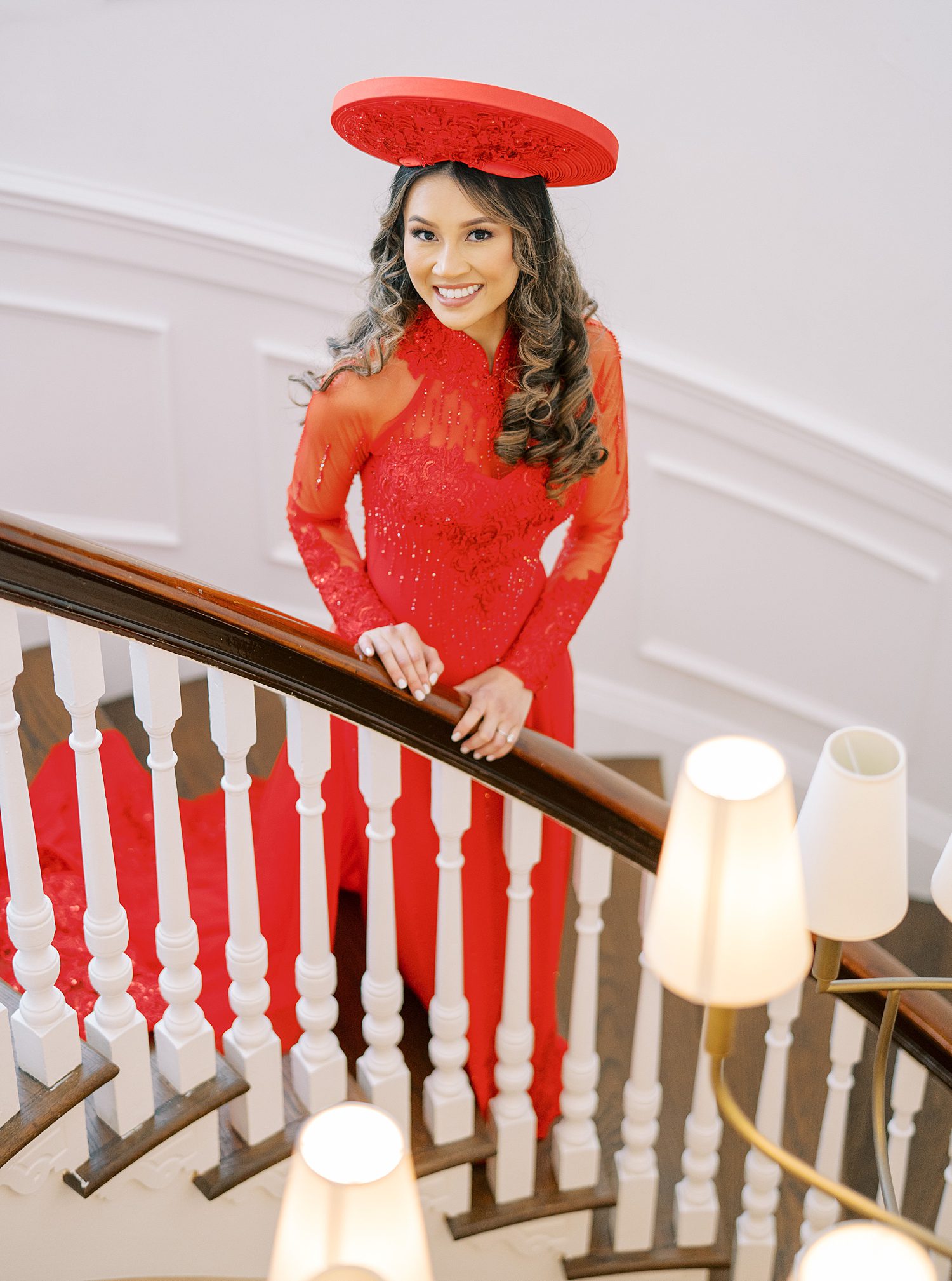 bride in traditional red Vietnamese wedding dress walks down steps inside the Tampa Yacht Club
