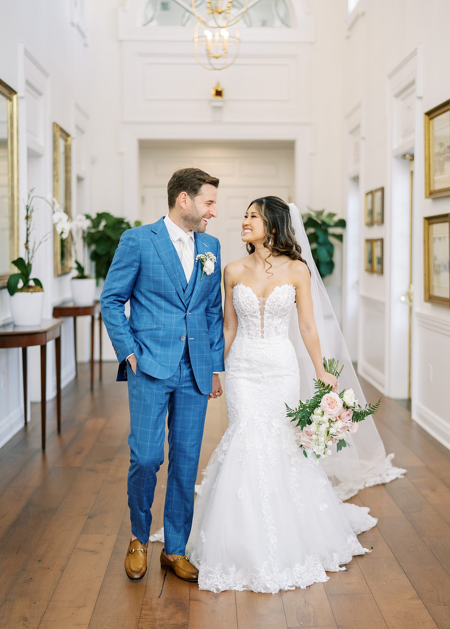 bride and groom hold hands walking down hallway at Tampa Yacht Club